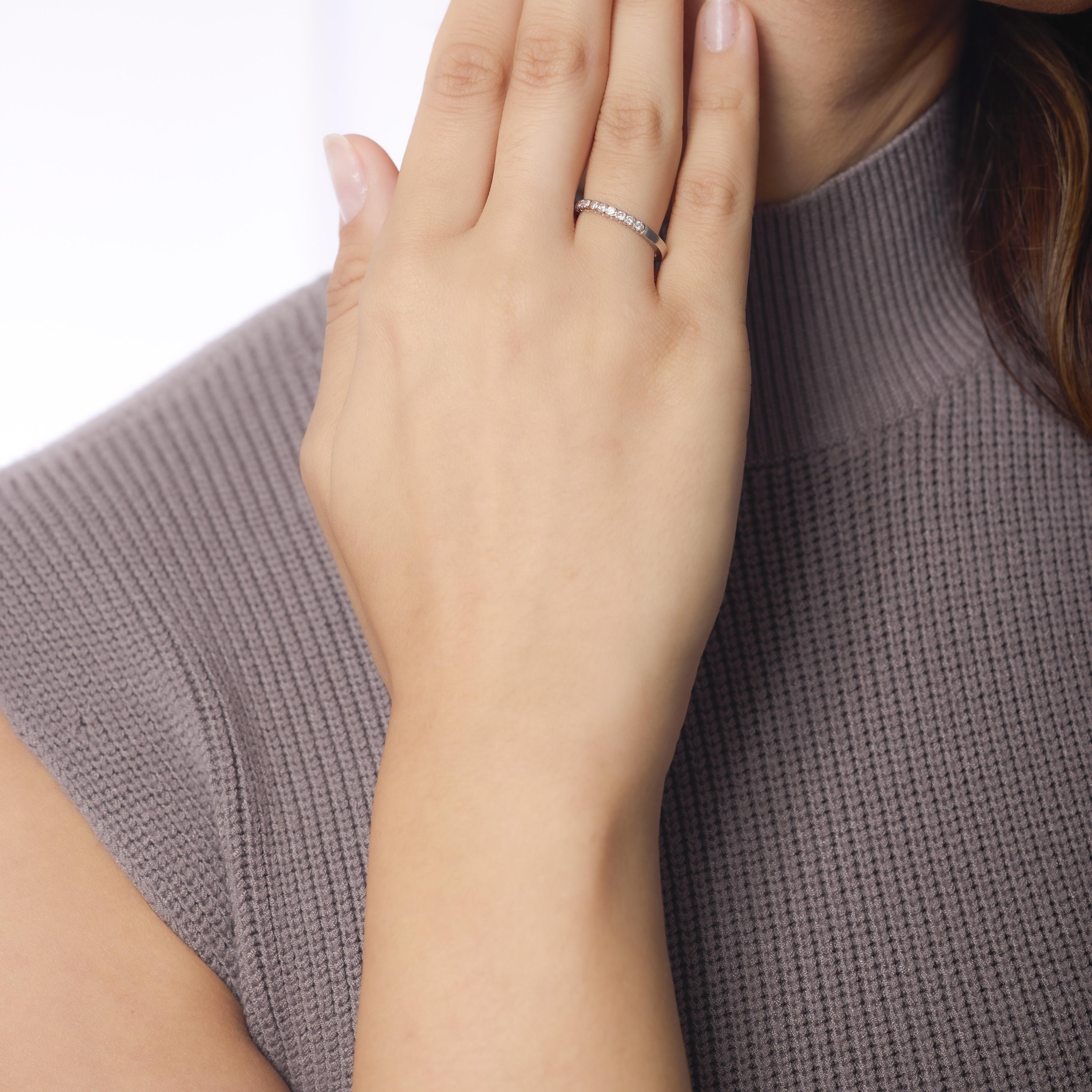 This Mid Century platinum wedding band glows with twelve crisp E-color round brilliant cut diamonds, offering clean sparkle and refined beauty. Crafted in the 1950s and marked for purity, it blends timeless elegance with enduring craftsmanship.