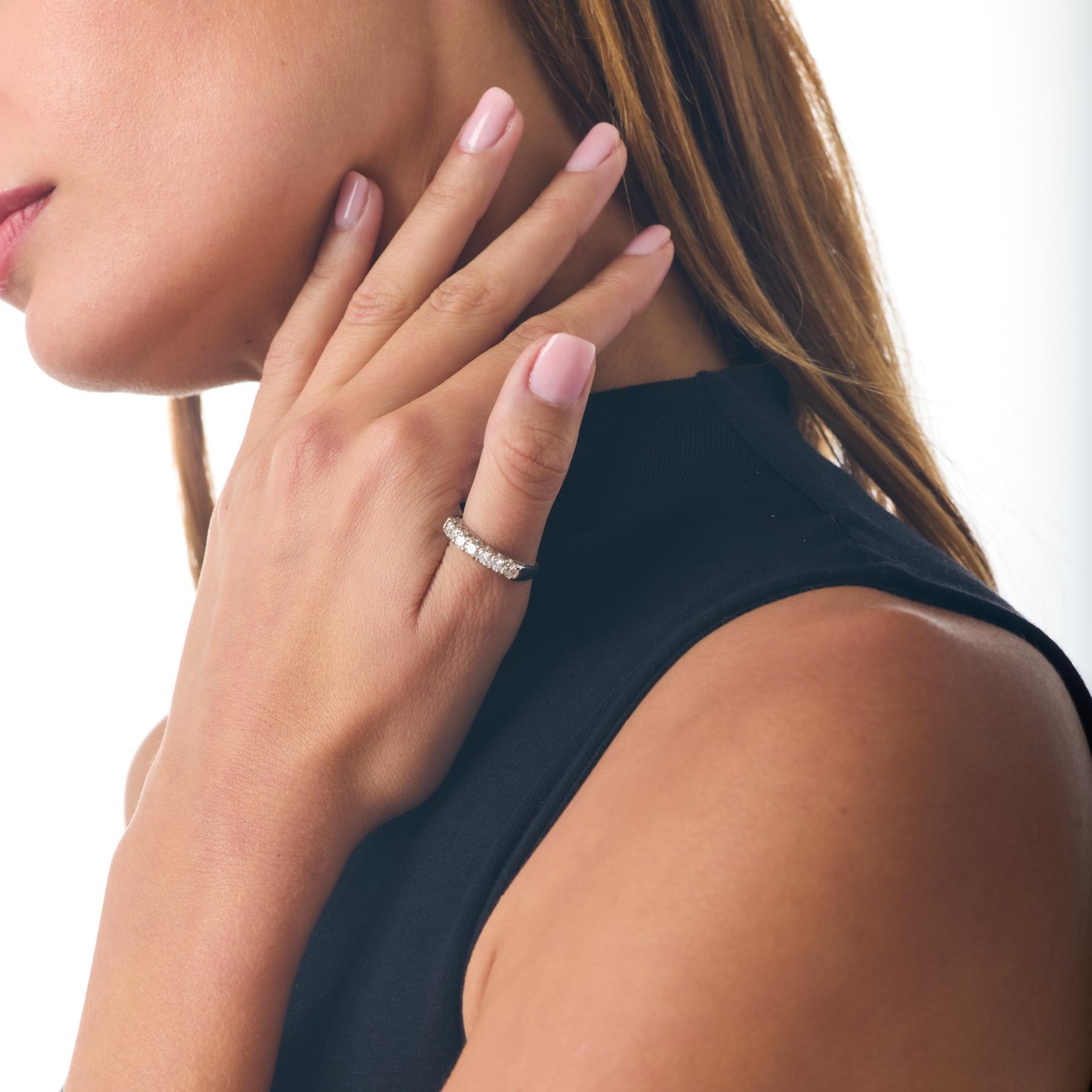 Cette alliance en platine du milieu du siècle offre une élégance raffinée et intemporelle grâce à sa rangée harmonieuse de diamants ronds brillants. Chaque pierre est sertie de manière à créer une ligne continue de scintillement, conférant au