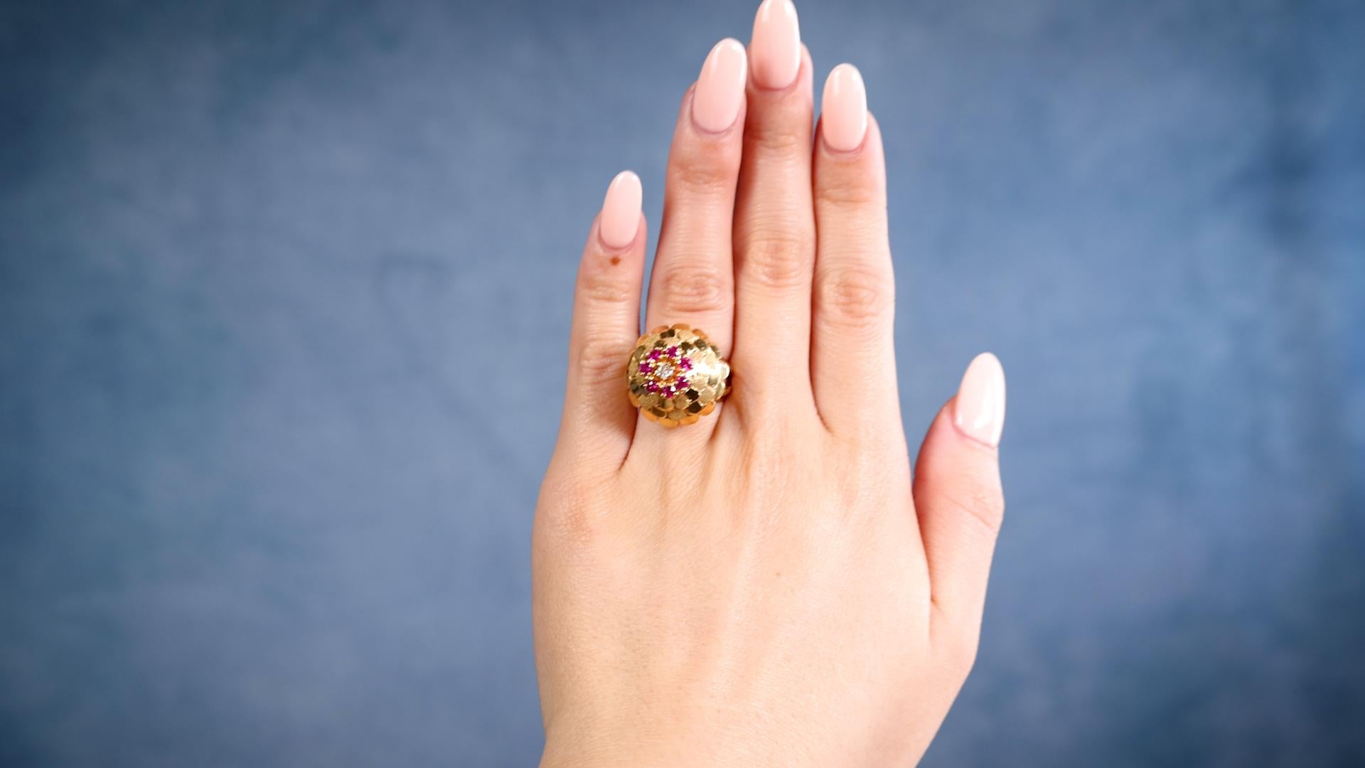 Ein Mid-Century Diamant Rubin 18k Gelbgold Cocktail Ring. Mit einem runden Diamanten im Brillantschliff mit einem Gewicht von ca. 0,15 Karat, Farbe J, Reinheit I1. Akzentuiert durch sieben runde Rubine im Brillantschliff mit einem Gesamtgewicht von