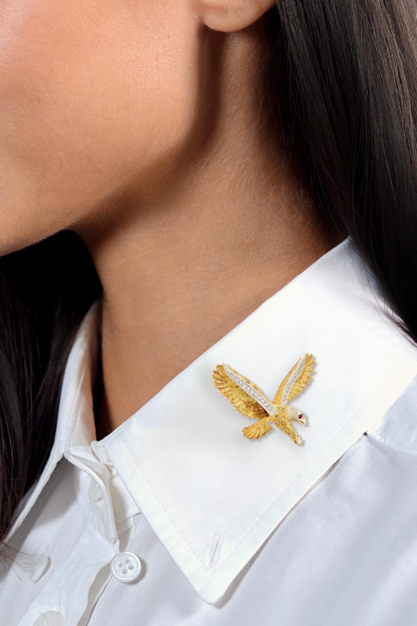 Brooch designed as a highly rendered eagle with outstretched wings
Yellow gold with white gold head - engraved with feather texture
Featuring platinum appliqué along the edges of the wings
Bead set with rows of graduated round brilliant cut