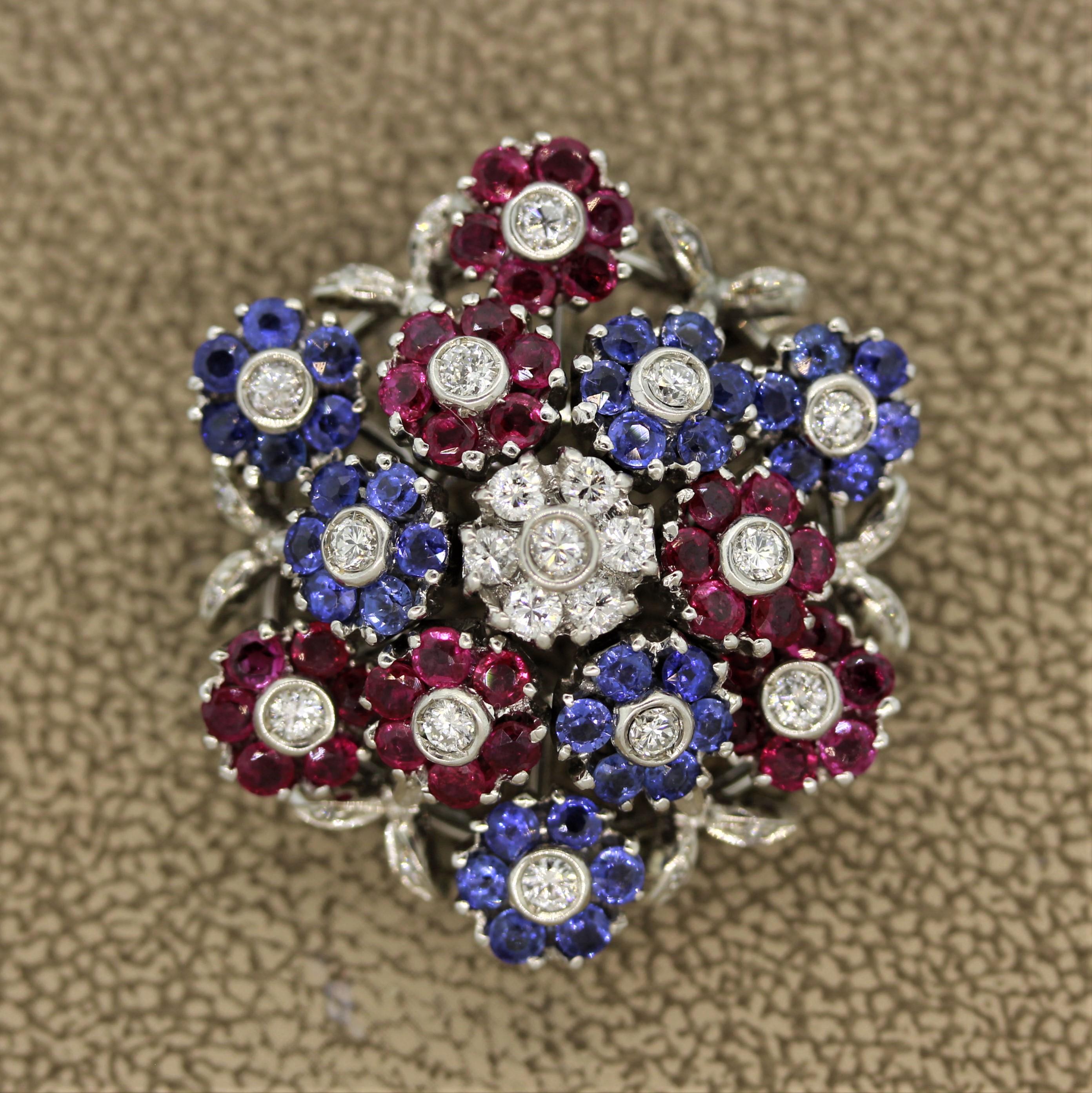 A mid-century treasure from the 1950’s, this brooch features approximately 5 carats of round cut diamonds, rubies and blue sapphires. They are set in 18k white gold in a unique setting that allows each individual flower to move or “tremble” in