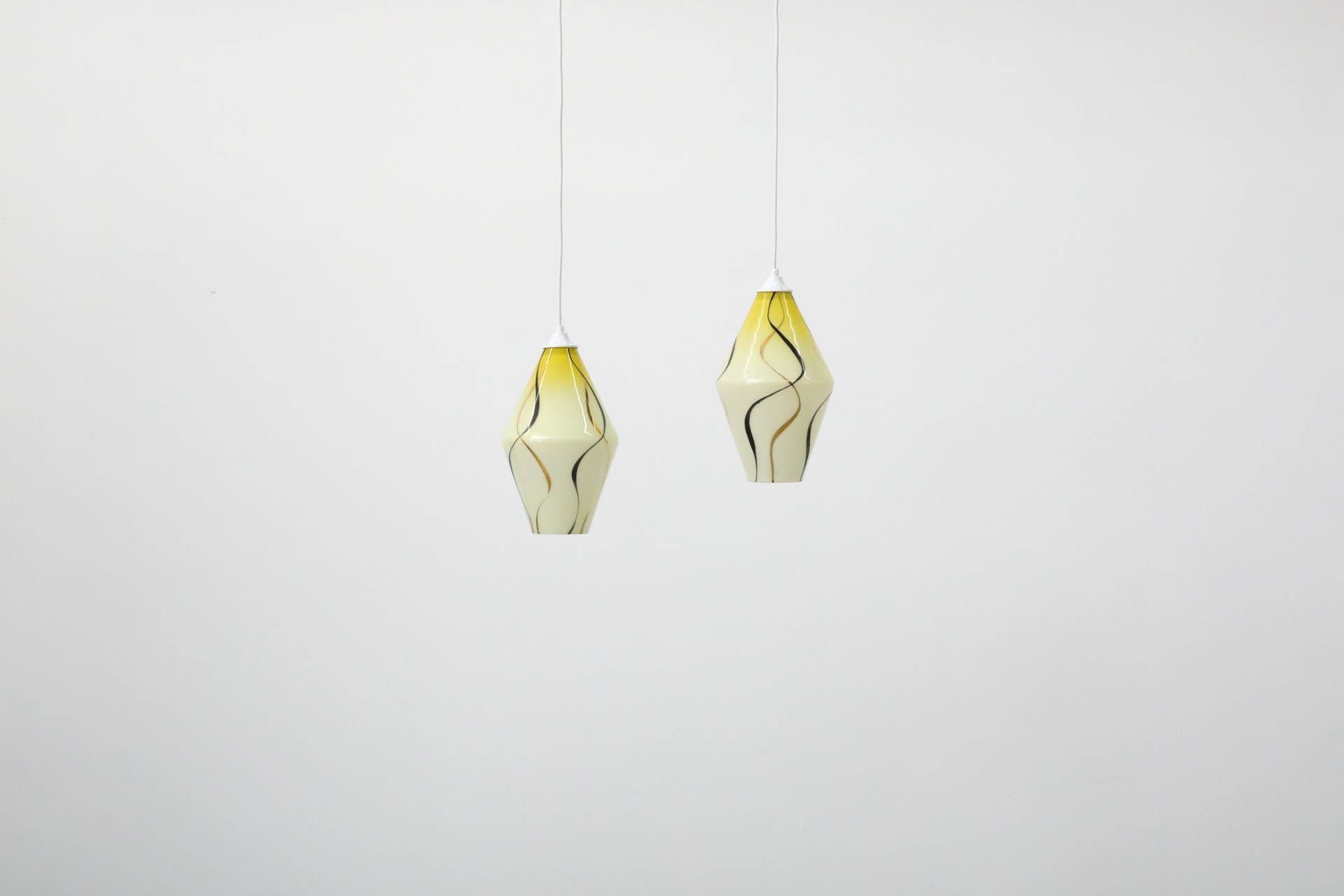 Pendenti da soffitto in vetro a forma di diamante di metà secolo con design stampato. Il vetro ha una colorazione variegata che va dal giallo al bianco, con vortici metallici neri e dorati. In condizioni originali, con un'usura tipica dell'età e