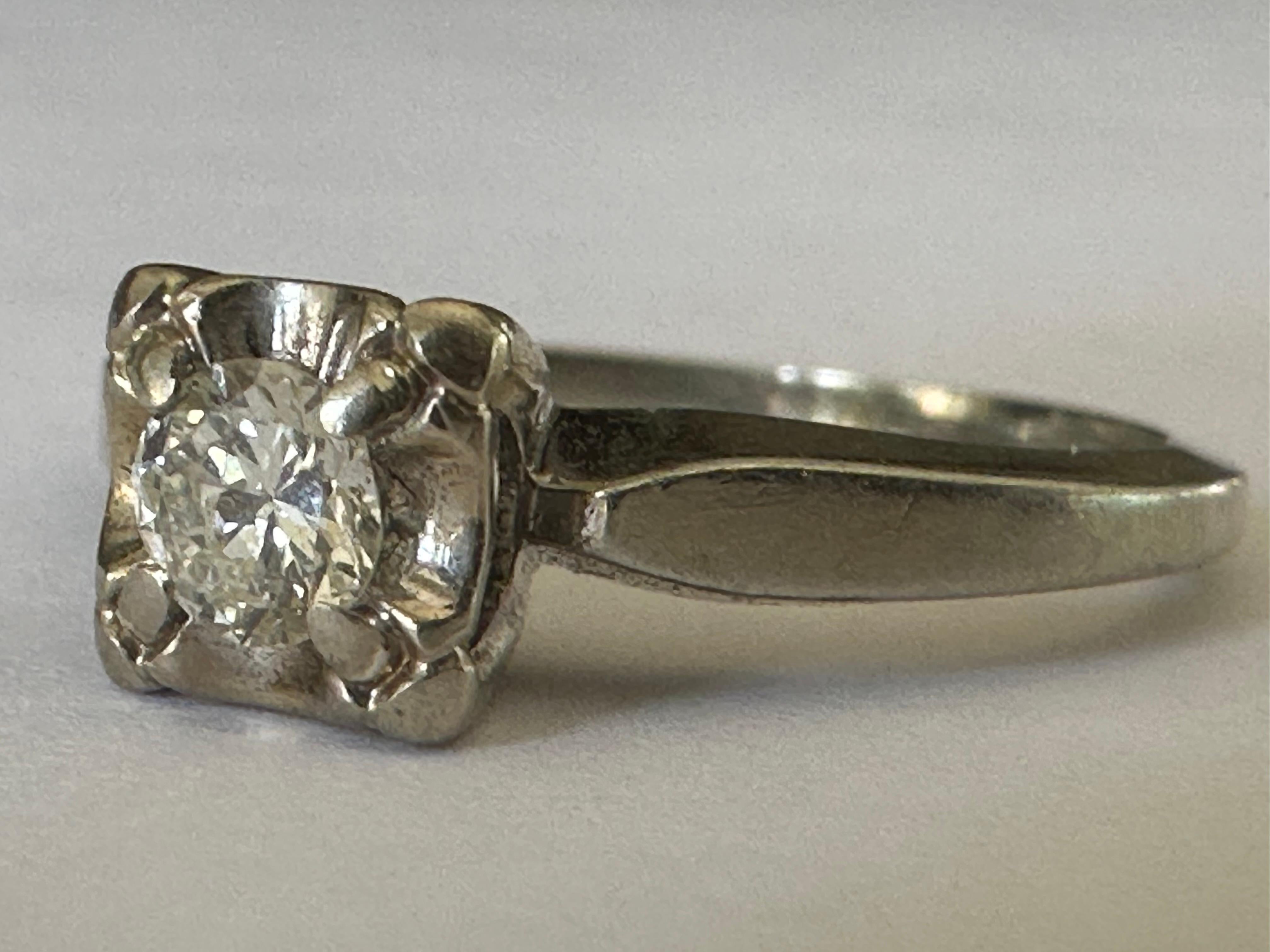 An Old European-cut diamond measuring approximately 0.20 carat, J color VS clarity, shines at the center of this classic, mid-century solitaire engagement ring crafted in 18K white gold. Circa 1940s.
