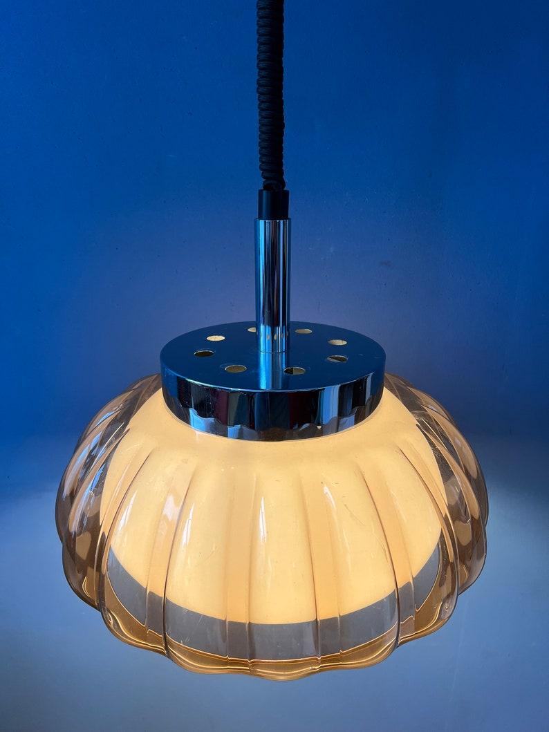 Lámpara colgante Dijkstra de mediados de siglo con forma de flor de la era espacial y doble pantalla de cristal acrílico. La lámpara consta de una pantalla exterior de cristal acrílico de color cobre y una pantalla interior blanca. La altura de la