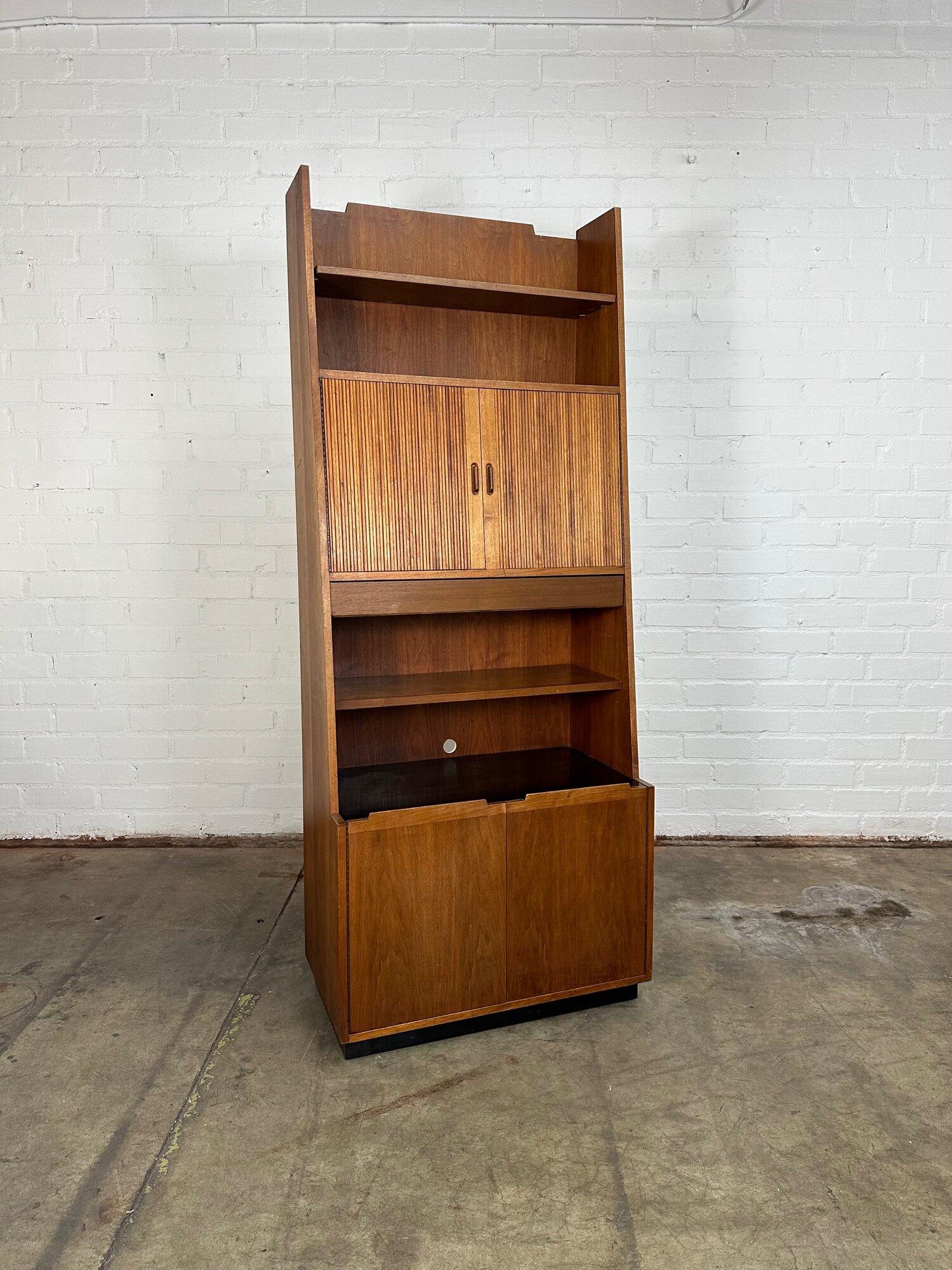 Dimensions: W32 D18 H80

Midcentury bookcase very reminiscent of Dillingham. The bookcase features two doors that appear to be Tambour but only give the illusion. The item is structurally sound and sturdy with a durable black laquer surface.
