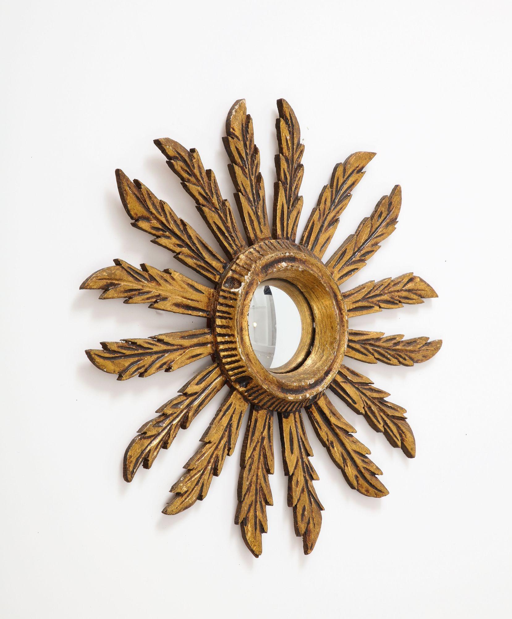 Miroir en étoile en bois doré du milieu du XXe siècle. Usure conforme à l'âge et à l'utilisation.
