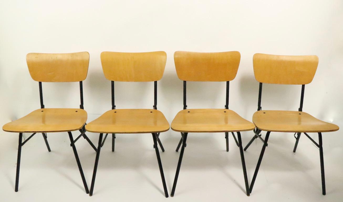 Table de jeu au design architectural chic et quatre chaises fabriquées par Cavalier. Construit en bois et en tiges de fer tubulaires, l'ensemble se replie pour faciliter le rangement et le transport. Solide, robuste et prêt à l'emploi, il est