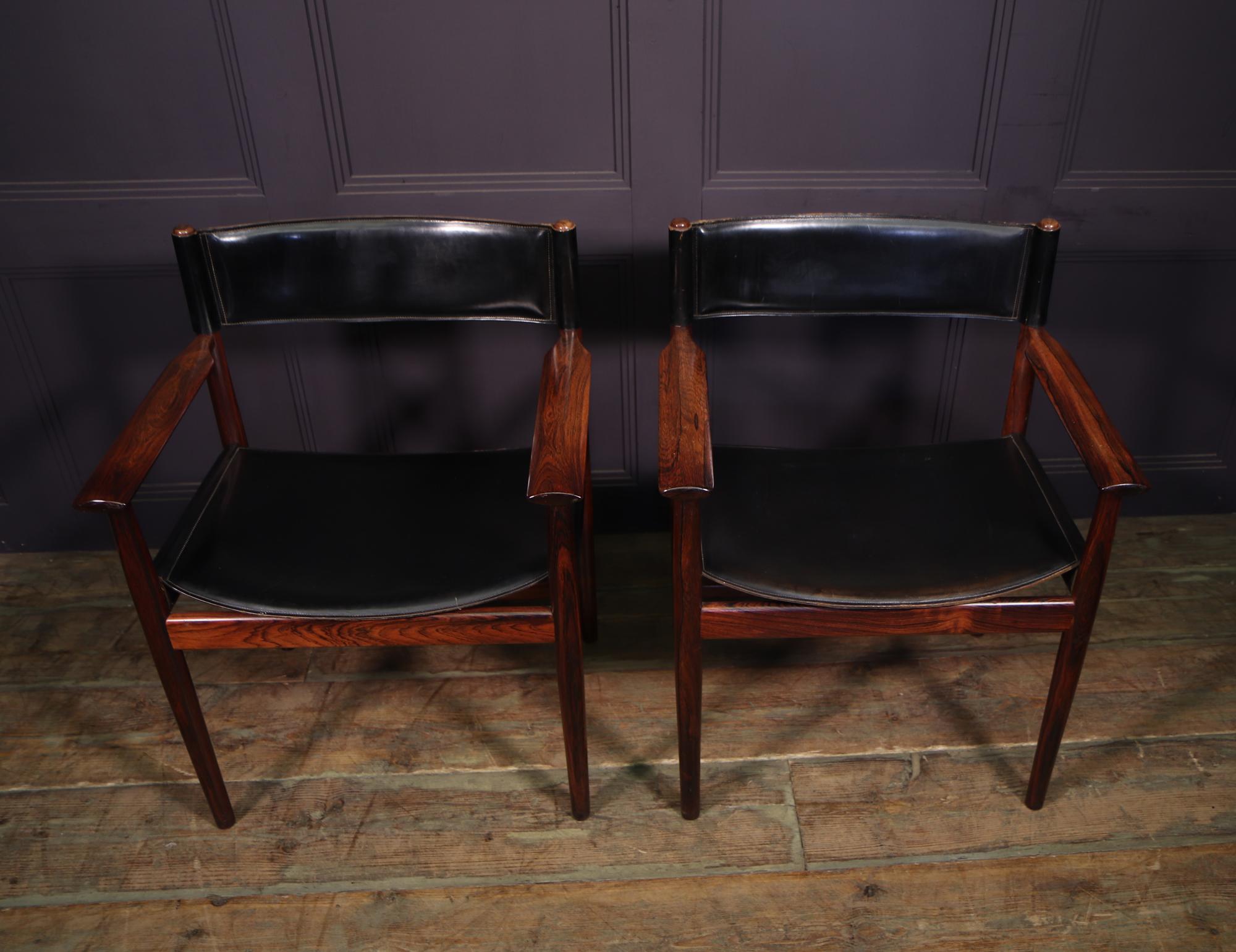 Set of four dining chairs, 2 carvers and 2 side chairs designed by Arne Vodder, manufactured by Sibast in Denmark circa 1950s. These chairs are made of thick black saddle hyde on a beautiful quality tropical hardwood base. Two labels underneath