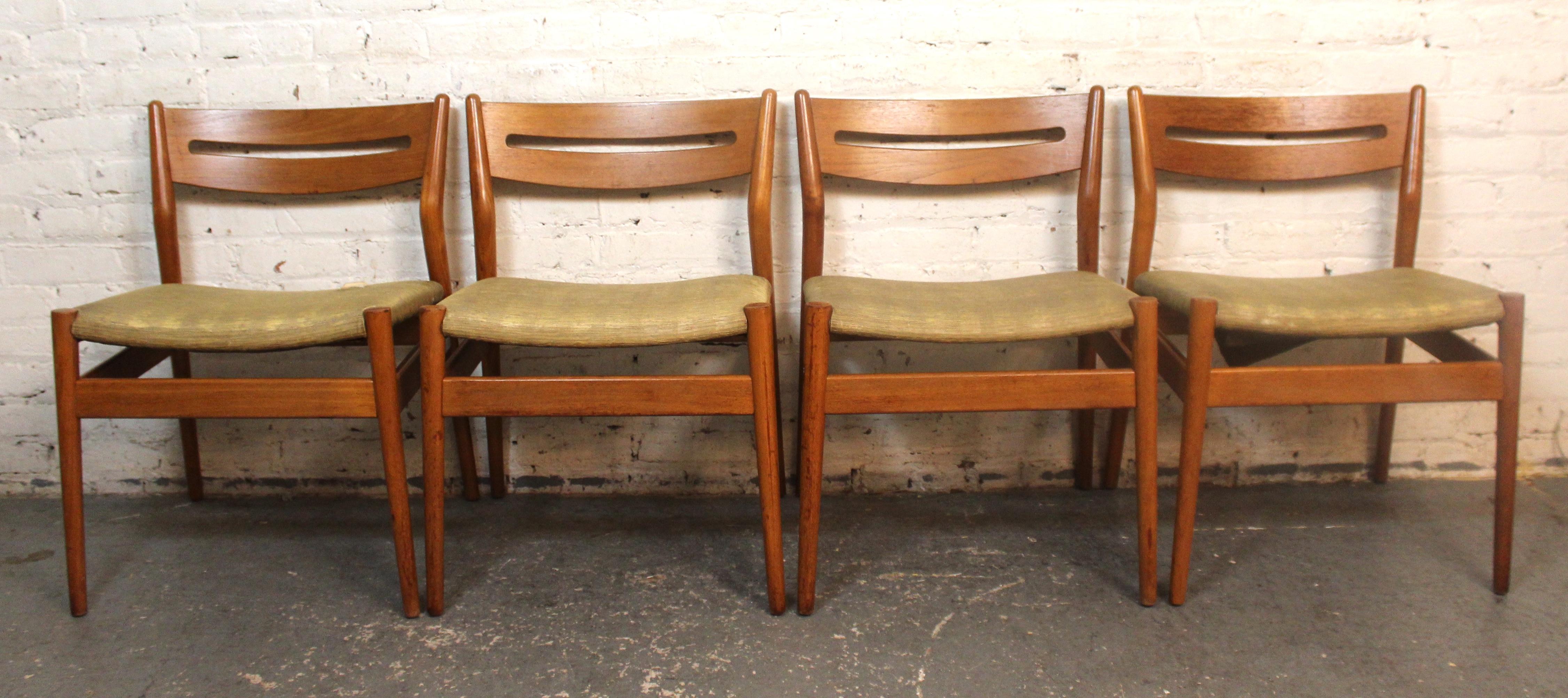 Set of four wide seat dining chairs by Grete Jalk for Sibast. Made of oak wood with a distinct arched back plank with oval cutout. The seat is 