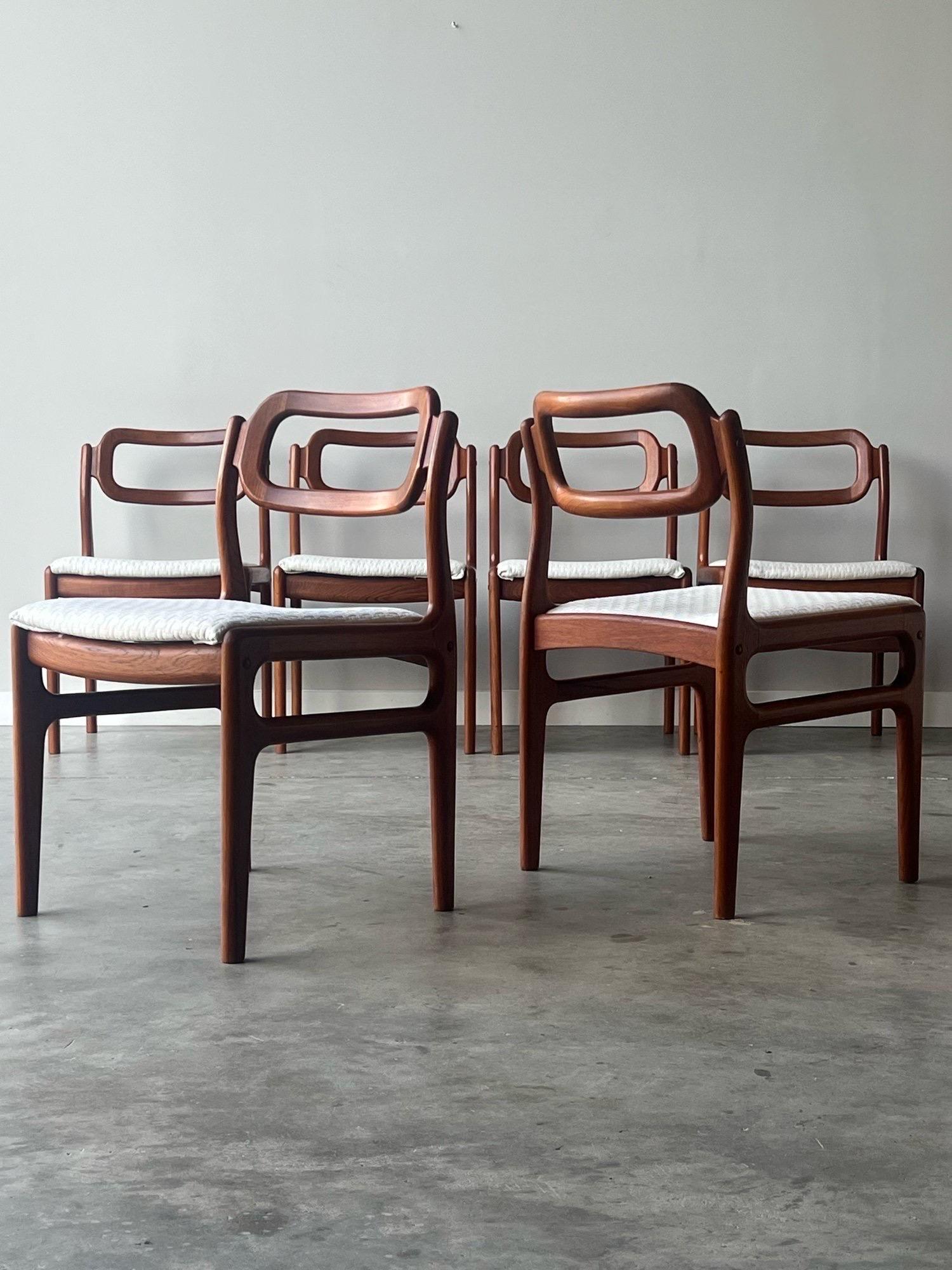 Set of six Scandinavian dining chairs designed by Johannes Andersen for Uldum Møbelfabrik, circa 1960s. Crafted from warm teak wood to form a unique frame. The backrest is arguably the most eye-catching design feature. Rectangular shaped with curved