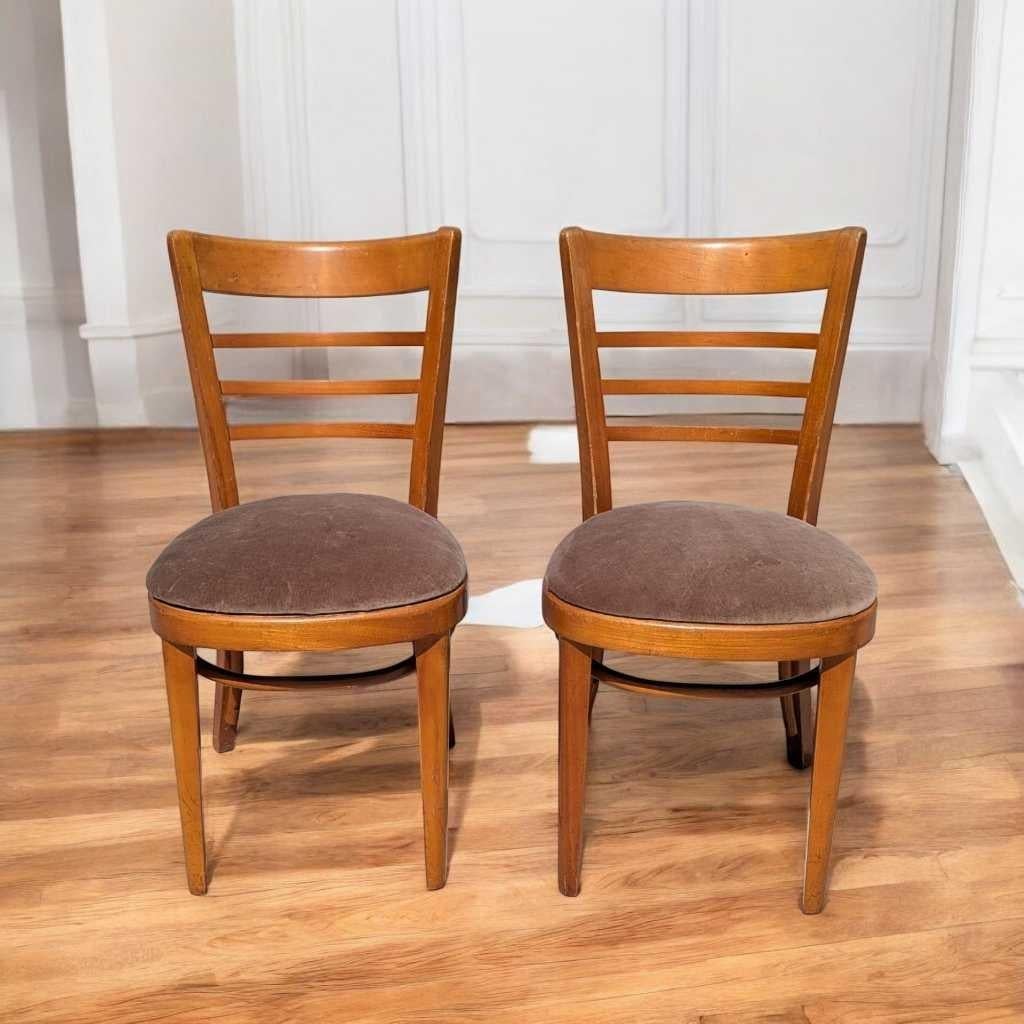A classic pair of mid-century bentwood dining chairs, attributed to Thonet, crafted in the 1930s. These chairs feature gently curved ladder-back slats, a warm wood finish, and upholstered round seats—an elegant example of European craftsmanship