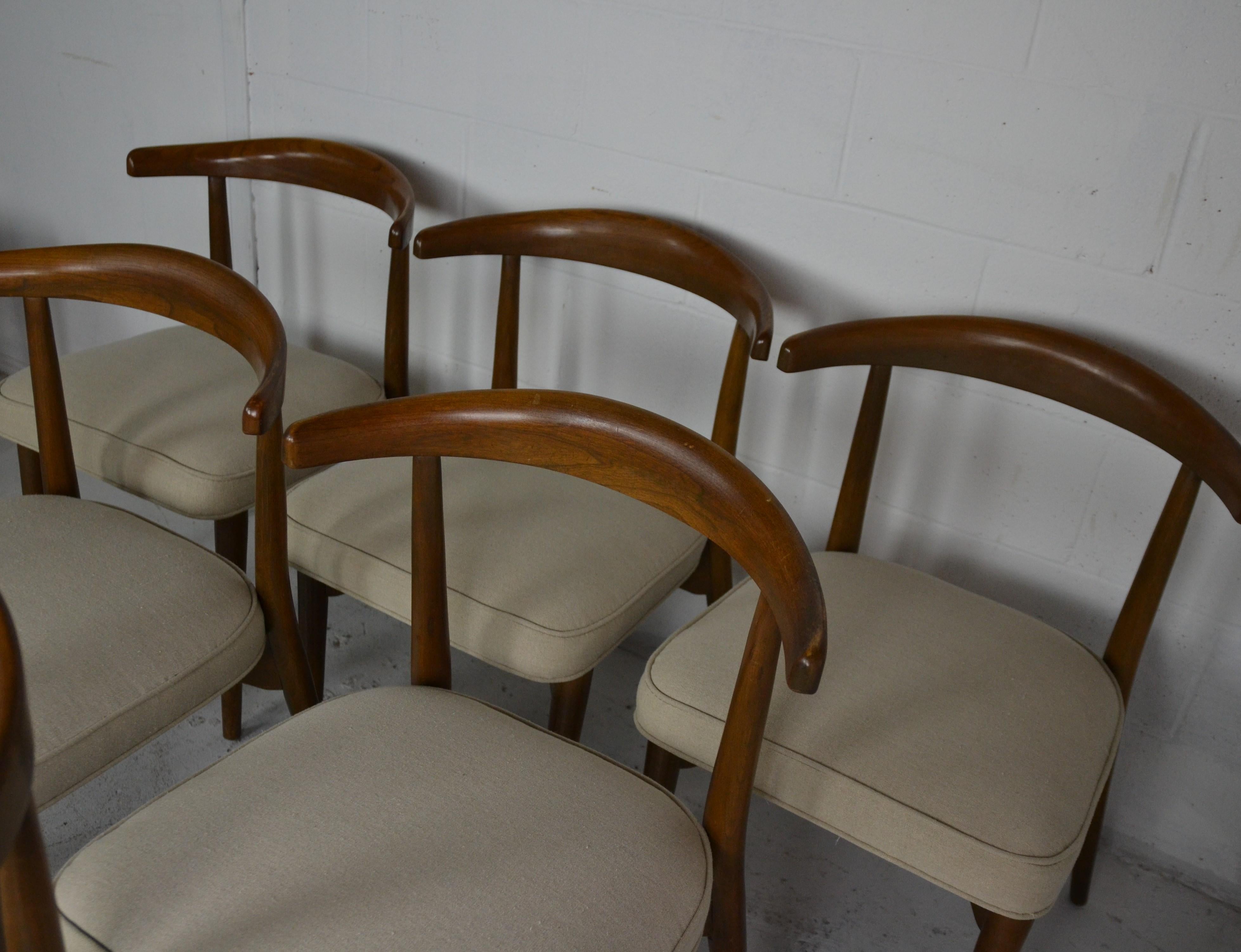 American walnut frame midcentury dining chairs. Seats are cover in a neutral fabric.