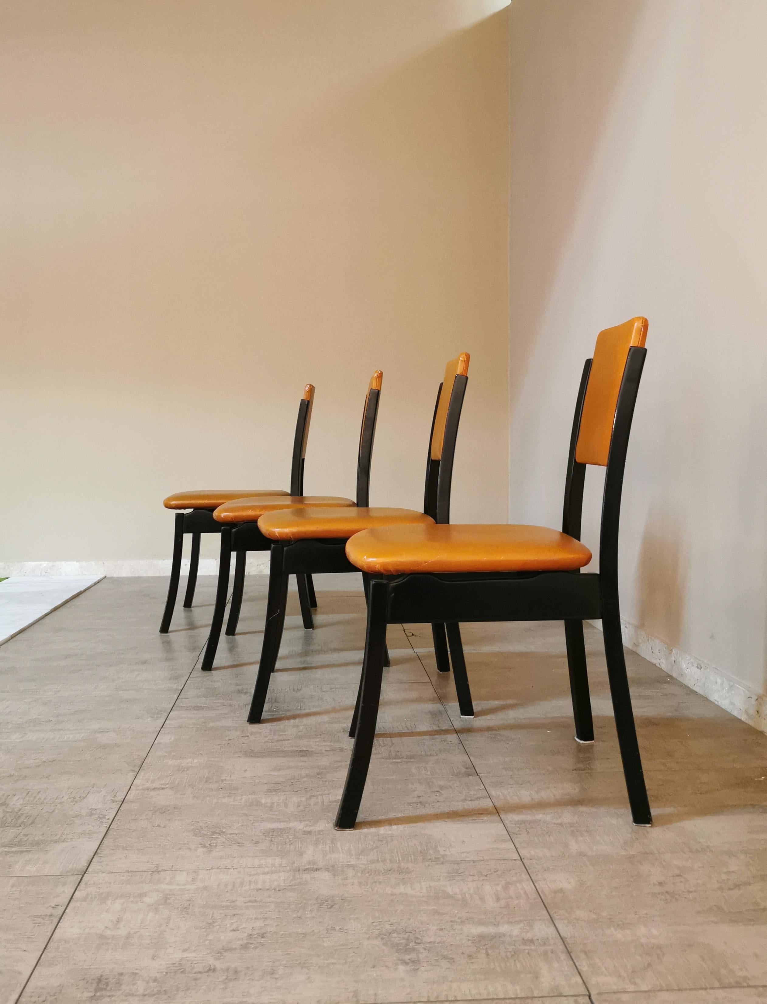 Set of 4 dining chairs designed by the renowned Italian designer Angelo Mangiarotti in the 70s. The chairs have a dark-toned wooden structure with particular legs that curve outwards. The seat and back are covered in leather-colored leather.