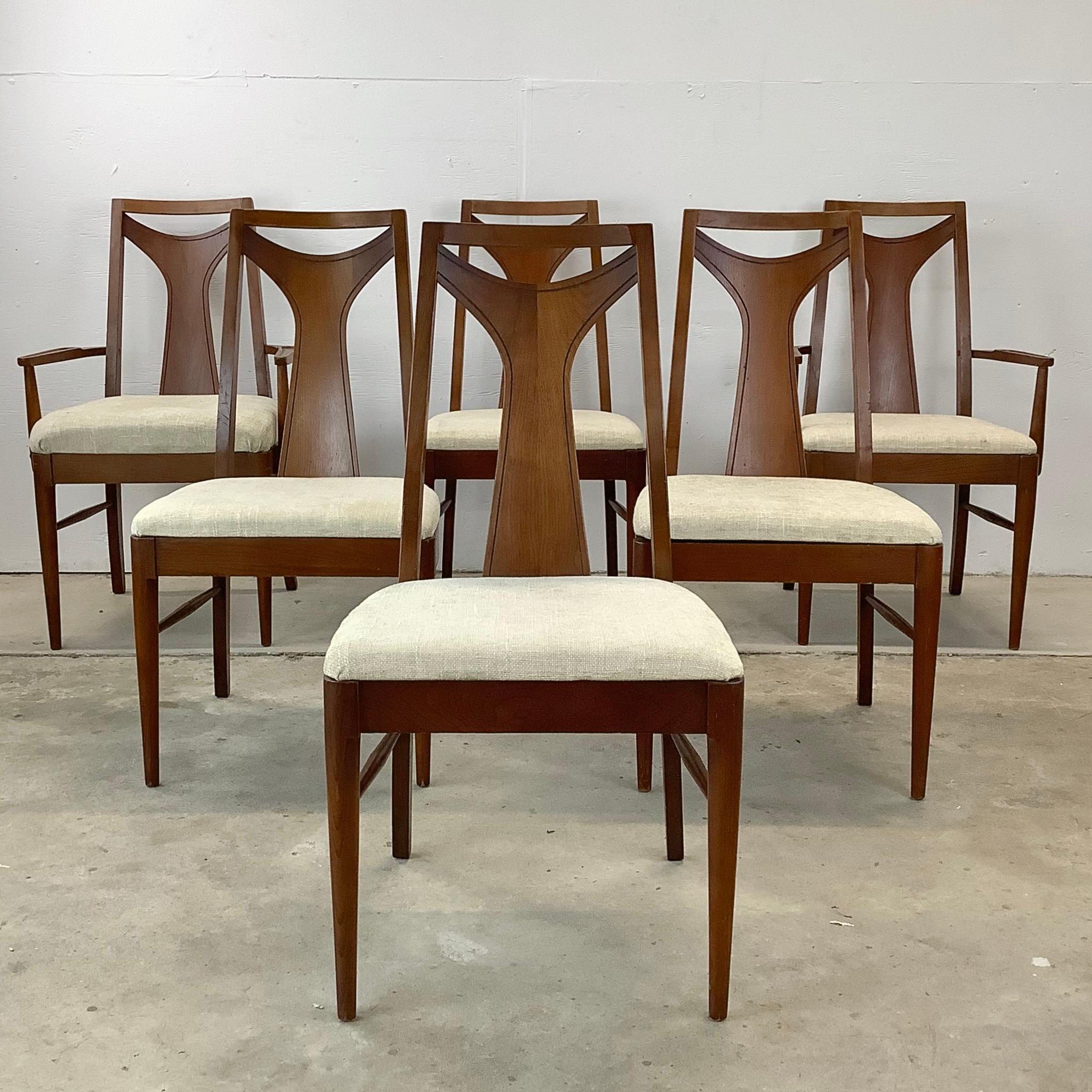 This striking mid-century set of six dining chairs beautifully combines comfort, style, and timeless elegance with vintage walnut finish and upholstery. This exquisite collection is a true testament to impressive mcm design and modern