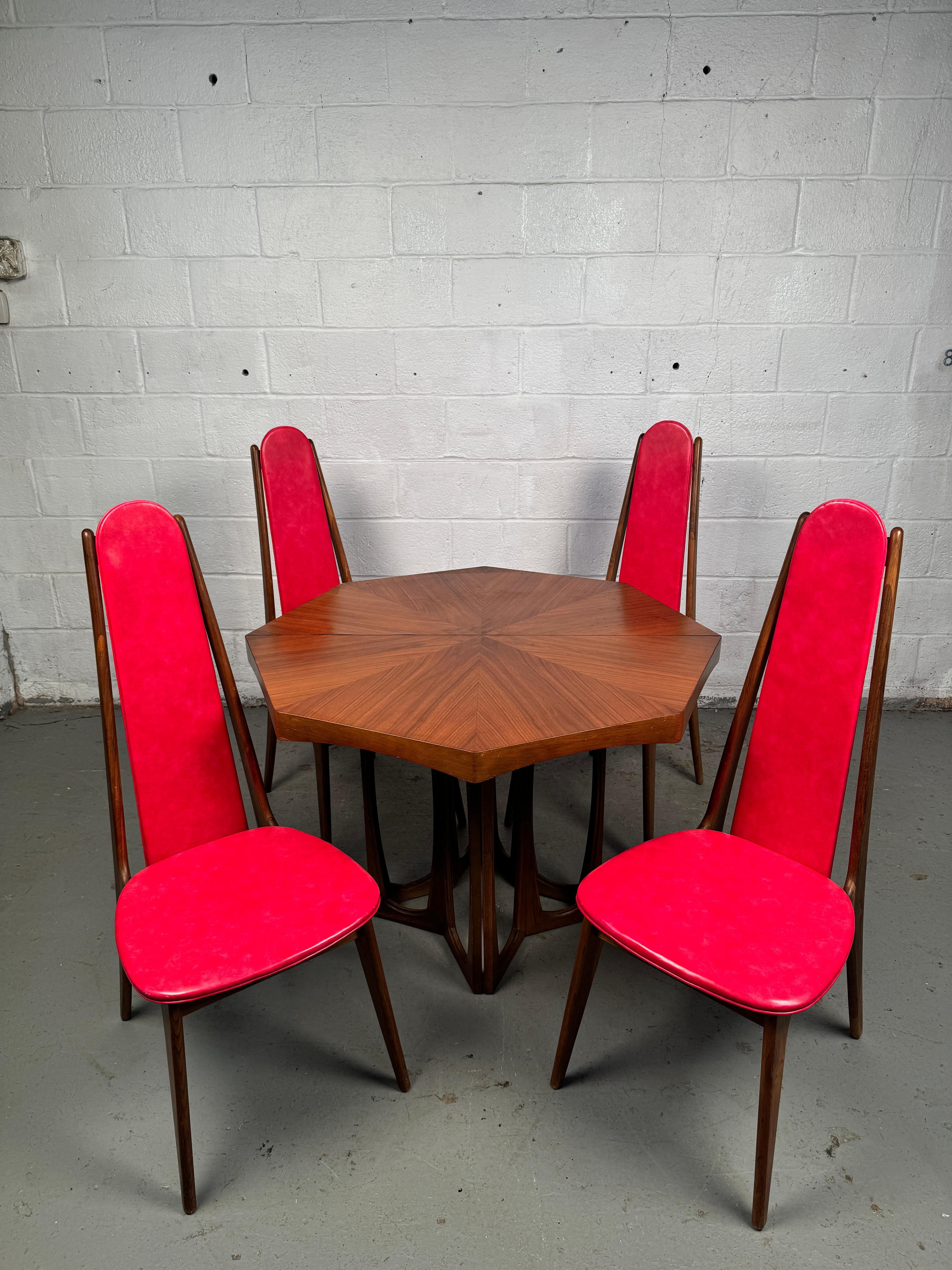Eleganza scultorea con un fascino iconico degli anni '60. Porta il dramma architettonico e lo stile senza tempo nel tuo spazio da pranzo con questo sorprendente set da pranzo Mid-Century Modern ispirato agli iconici design di Adrian Pearsall.