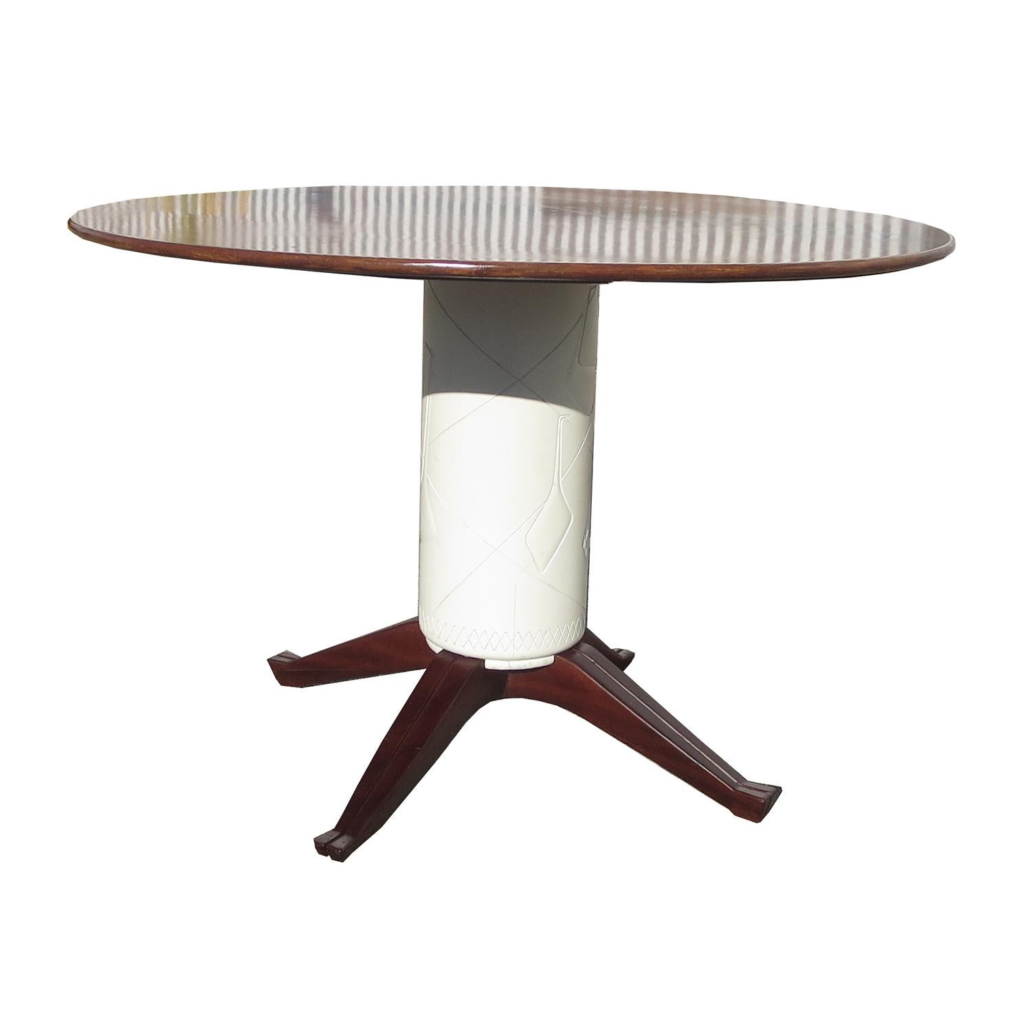 This charming and stylish table is the perfect scale for a smaller dining room, or breakfast area. The top is finished cherrywood, and the four legs are a dark walnut. The center post is a carved and painted wood. The finishes are original, and it