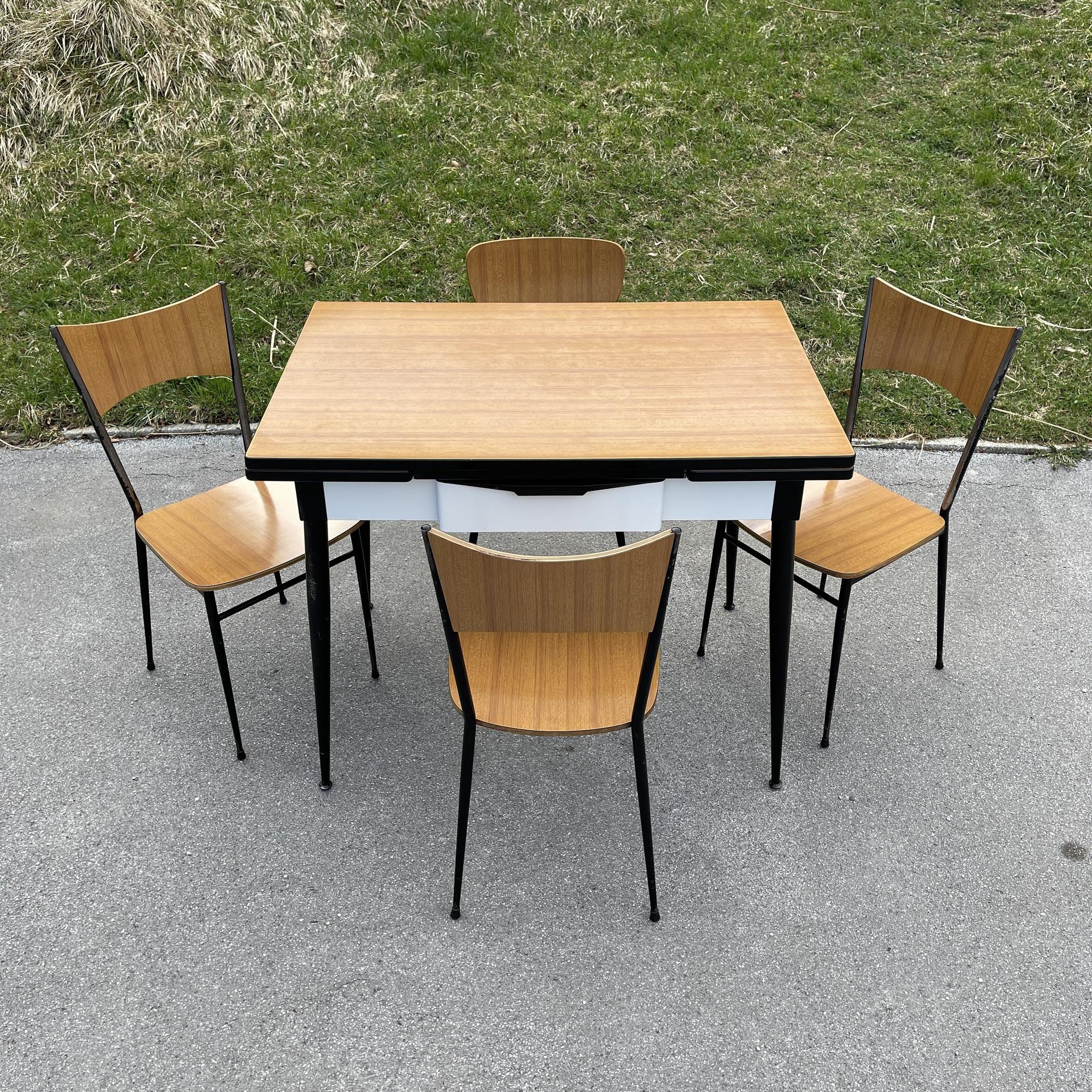 Mid-century dining table and 4 chairs by Salvarani Depositato made in Italy in the 1950s The design is fantastical 'aviator'.

The desktop is made from Formica and shows only light wear and tear despite its age.
To the sides there are recessed