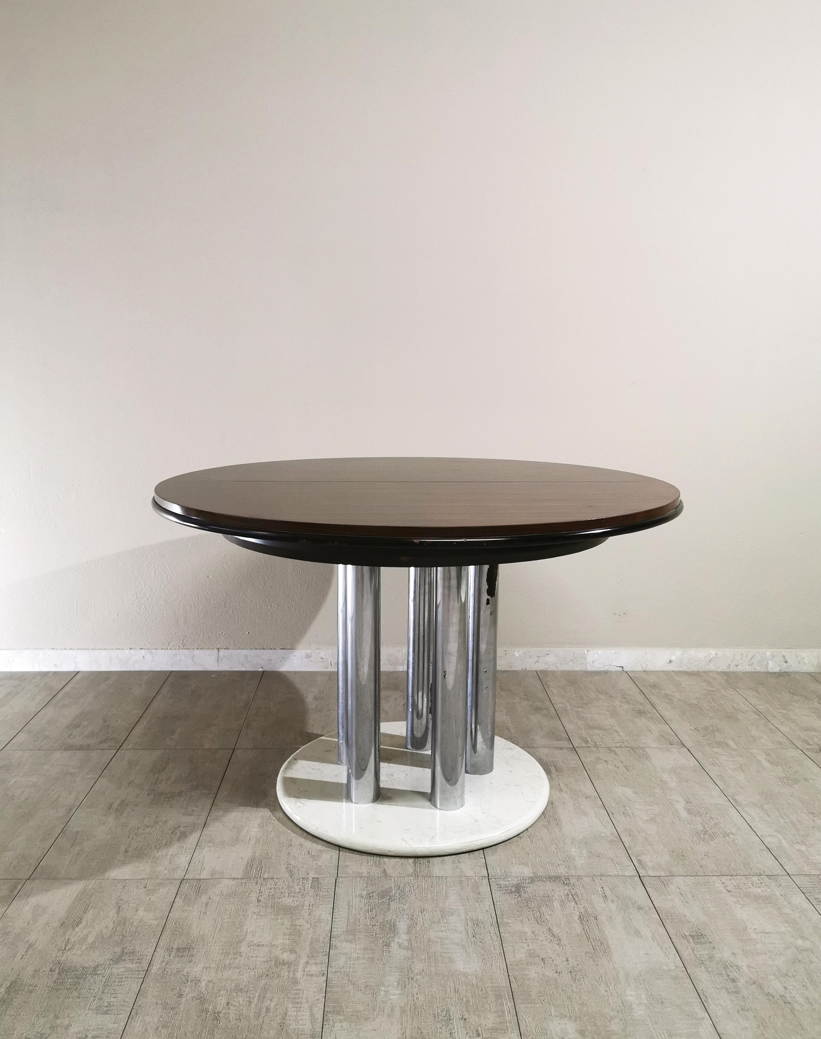 Round extendable dining table from the Livenza furniture factory. The table has a mahogany veneered top with 4 chromed metal tubular supports underneath that rest on a round white marble base. Italian production of the 1970s.