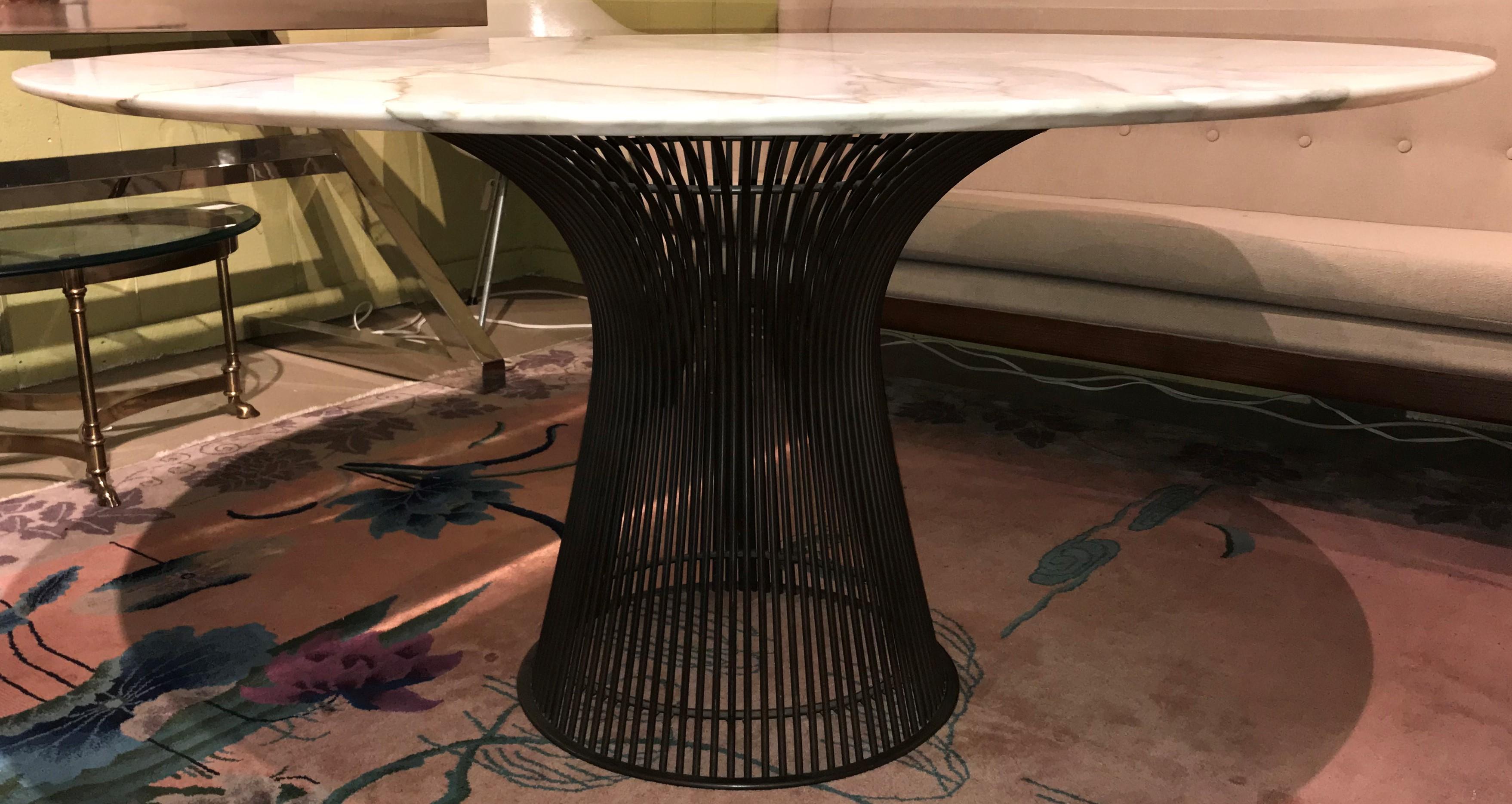 A sleek form round dining table designed by William Platner for Knoll International with a Carrara white marble top surmounting a twisting steel rod or wire frame with a metallic bronze finish, circa 1960s-1970s, in very good overall condition, with