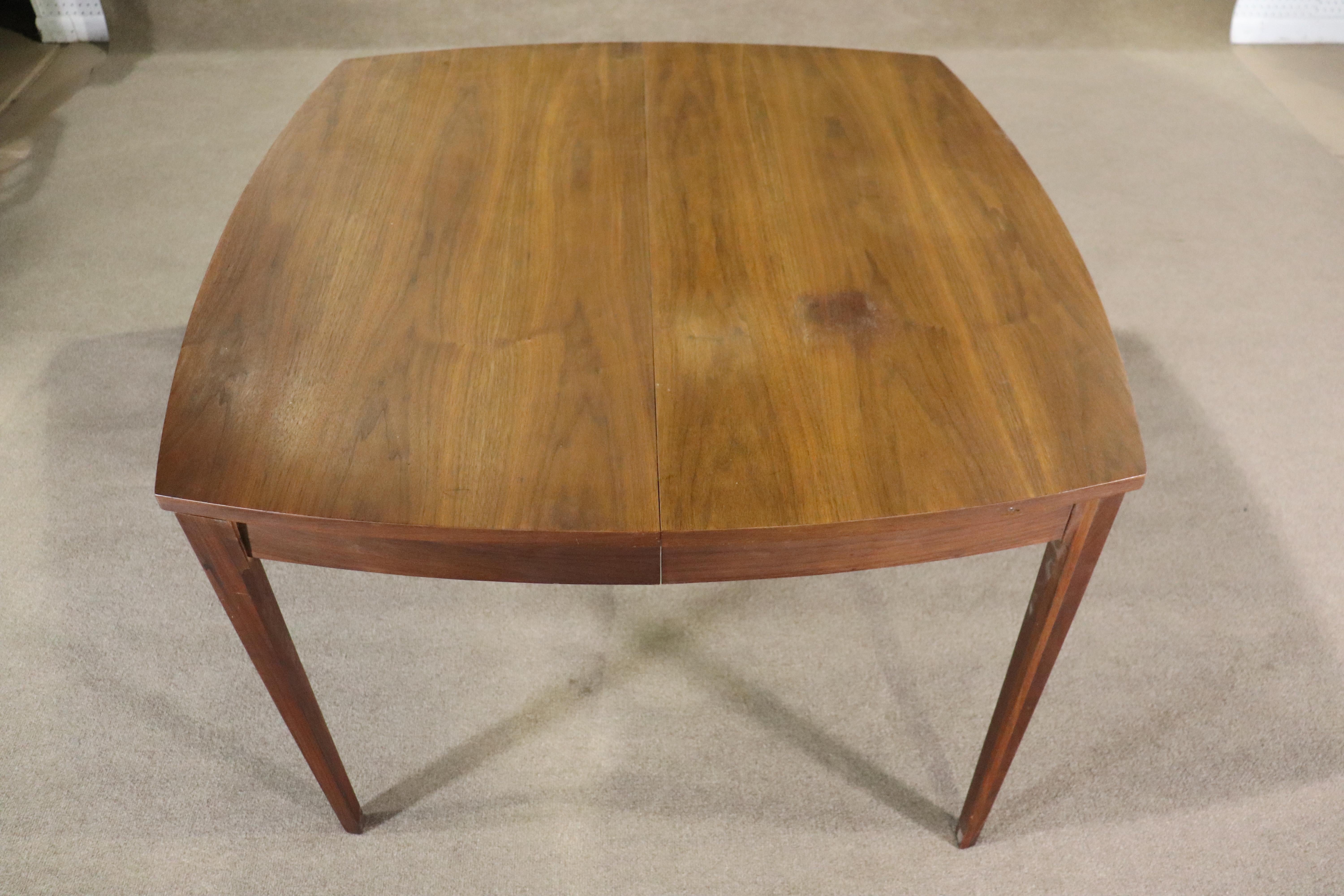 This Walnut dining table can be the perfect mid-century addition to your dining room, whatever the size. With wonderfully crafted sculpted legs, walnut veneer, and 3 leaves to constitute the modern design, this modular dining table can fit a variety