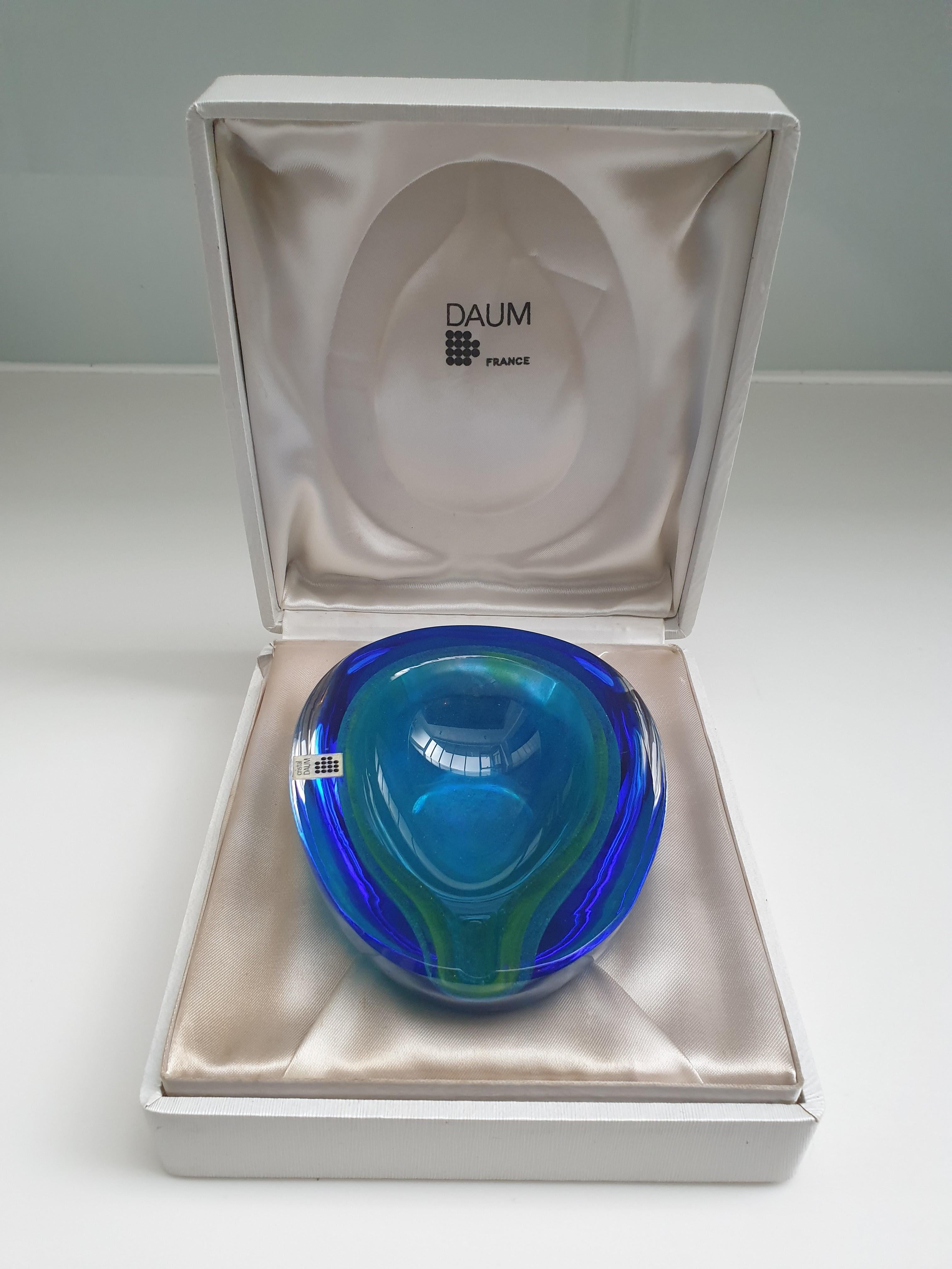 Schöne leuchtende Kristallglasschale/Aschenbecher  von Daum France. Der blau-grüne Farbton erinnert an das Meer. Es ist ungewöhnlich, einen so schönen Ton zu finden. Sie wird mit einem Daum-Aufkleber und einer eingravierten Signatur auf dem Sockel