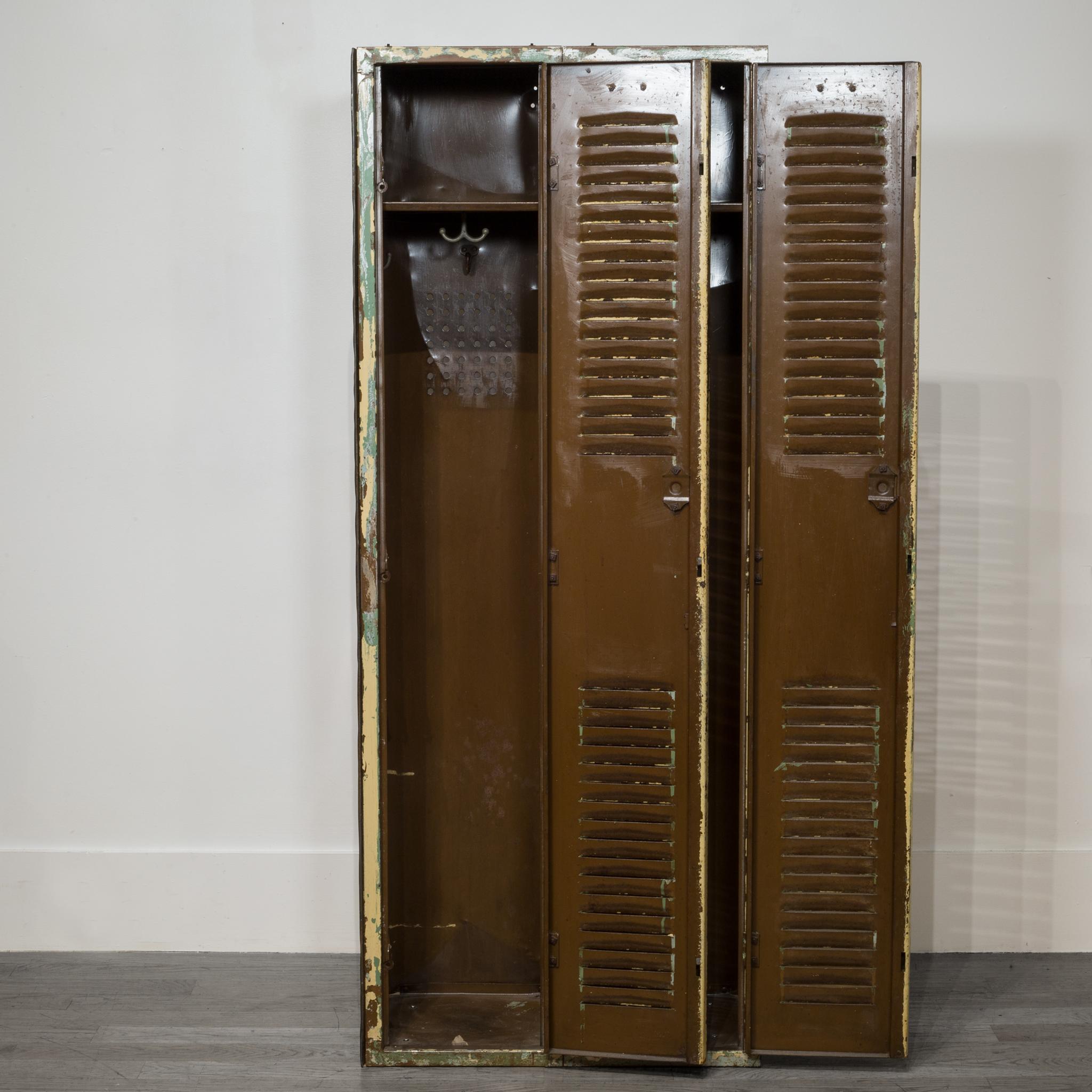 About:

This is an set of distressed metal school gym lockers with original number plates. Each side has a top shelf with several clothes hooks attached. The two lockers are attached and one unit. This pair has retain some of its original finish