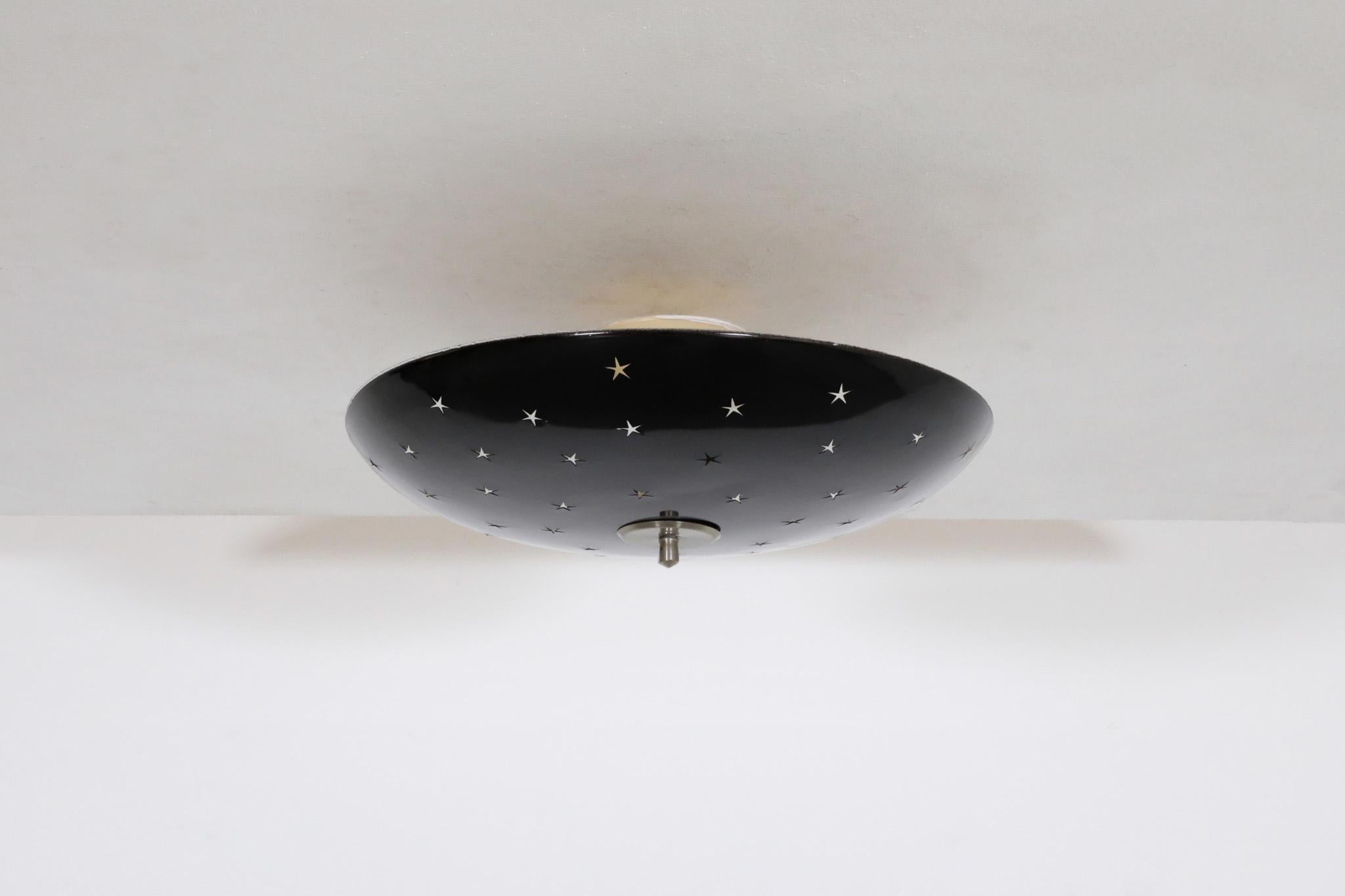 Mid-Century, flush mount, domed, black enameled ceiling light with retro star cutouts. The dome is in good condition with wear consistent with its age and use. The fitting hardware may not be original, the bullet shaped canopy is original and is