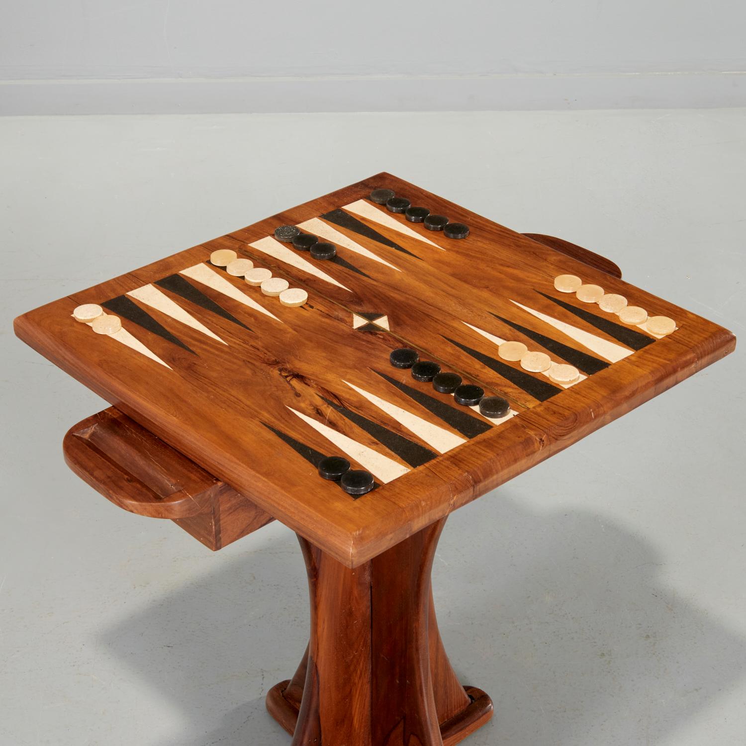 Mid 20th c., In the style of Don Shoemaker furniture: enamel inlaid tropical wood, the rectangular top on cruciform pedestal, with long two sided drawer. This piece retains the original 30 backgammon tiles with matching enamel surface. I love this