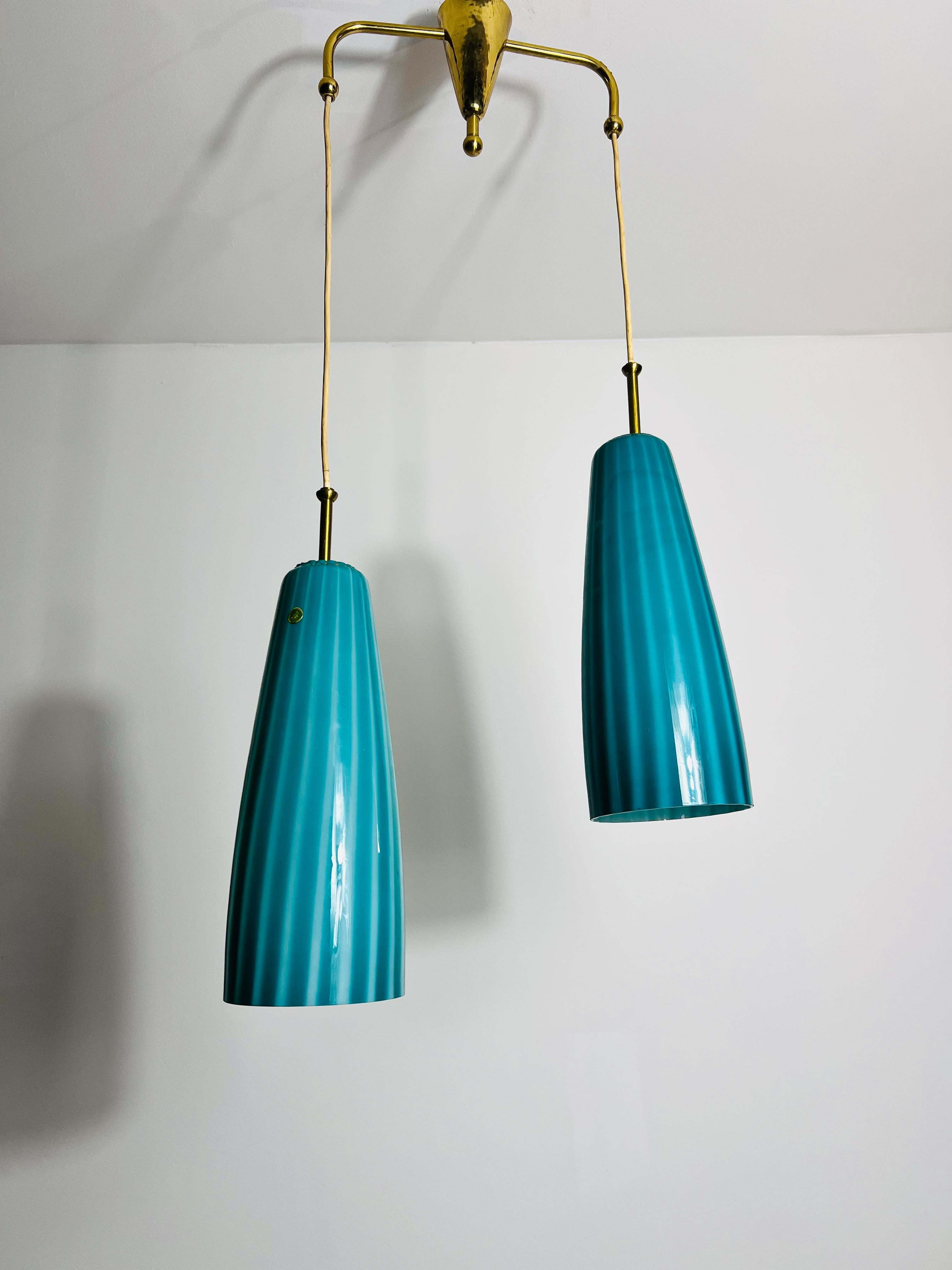 This exquisite Murano glass pendant lamp from the 1960s showcases the timeless elegance of mid-century Italian design. Featuring two unique lampshades crafted from Murano glass, the lamp boasts a stunning light blue-turquoise color that transforms