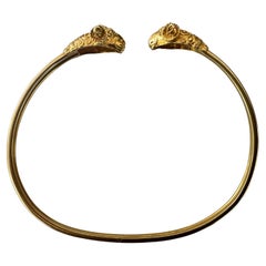 Brazalete de oro flexible con doble cabeza de carnero de mediados de siglo