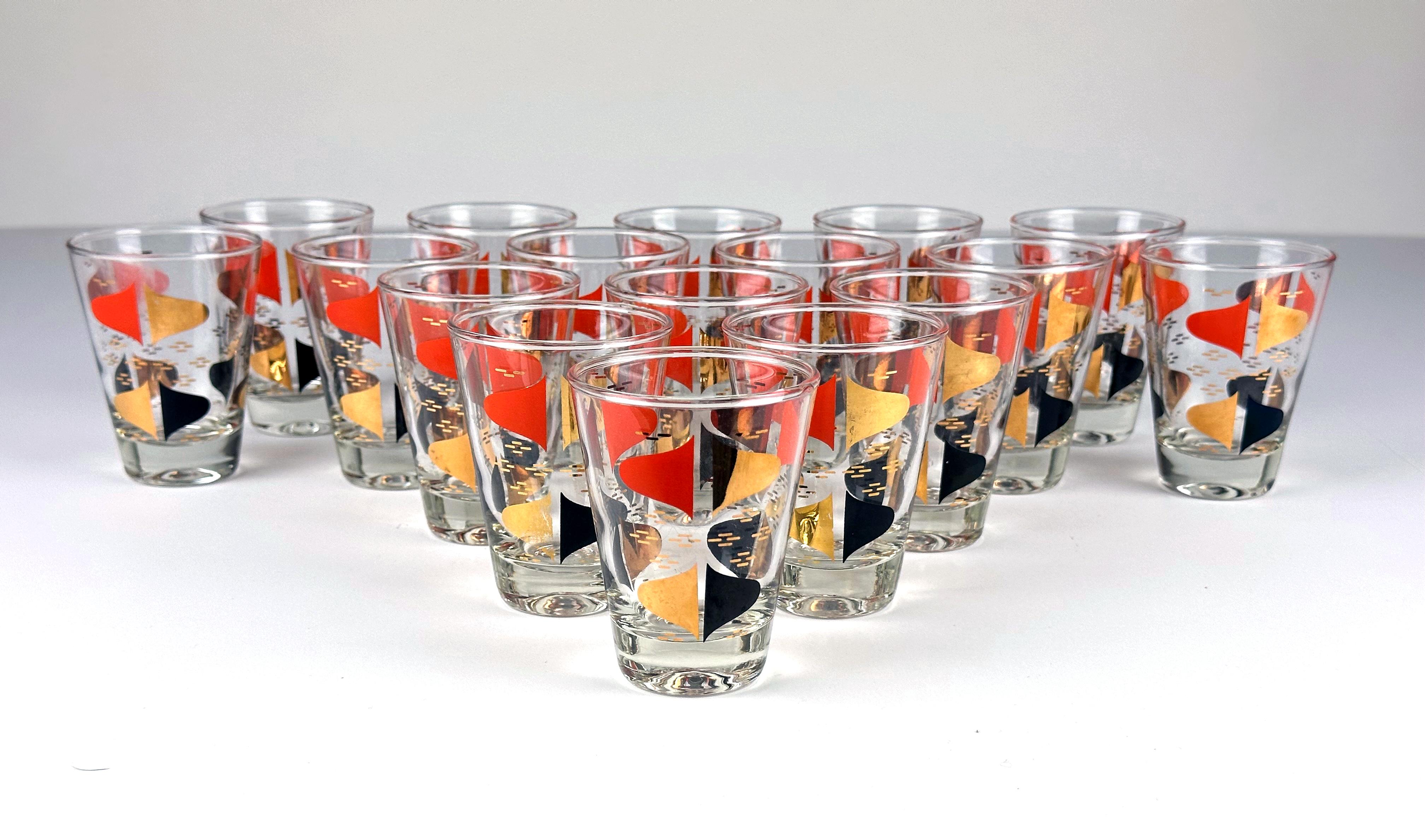 A striking example of Mid-Century glassware design, this set of 17 double shot glasses by Anchor Hocking features an iconic Florentine pattern in bold tones of red orange, jet black and metallic gold leaf. The abstract motifs have been beautifully