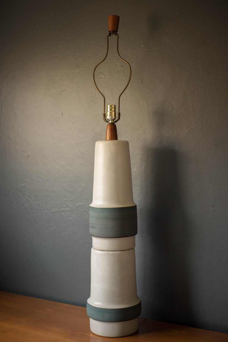 Vintage hand thrown ceramic pottery lamp by Gordon and Jane Martz for Marshall Studios. This oversized table lamp features a sculptural double stacked form in a white glaze and brushed matte blue finish. Includes a three way switch mechanism.