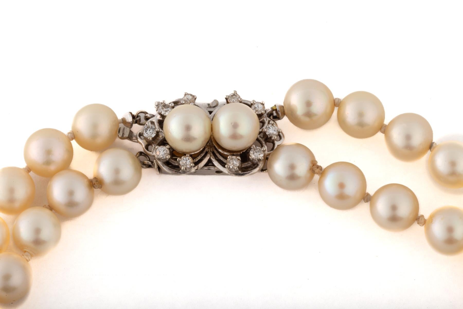 A double strand of 7.143 mm cultured pearls close with a beautiful pearl and diamond clasp. Pearls are classic worn today as well as in the Georgian Period. These strands are cream in color with a touch of pink. The beads are knotted individually