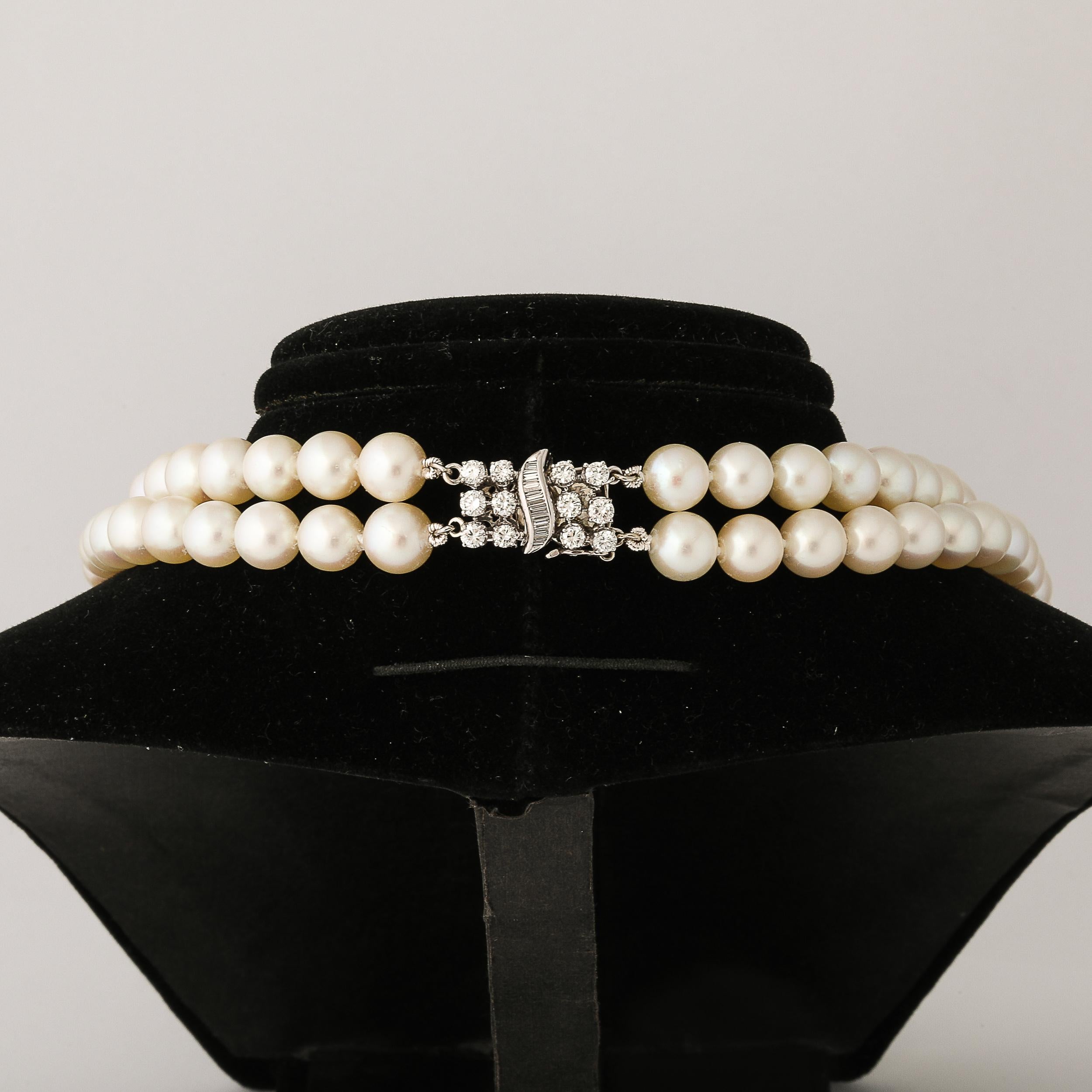 This elegant double strand pearl necklace is made of 104 7 mm cultured pearls of fine quality with a slightly rose luster and fitted with a diamond and 14k white gold clasp set with 12 round brilliant cut diamonds of approximately 1/3 carat and also