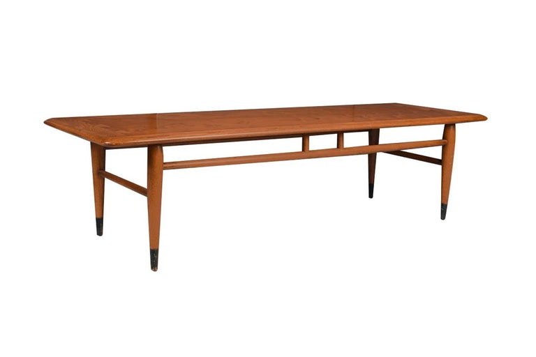 An American walnut and oak coffee table by Andre Bus for Lane Furniture in Altavista, VA. This Mid-Century Modern coffee table in walnut veneered and solid oak features beautiful contrasting dovetail detail on the top that identifies it as part of