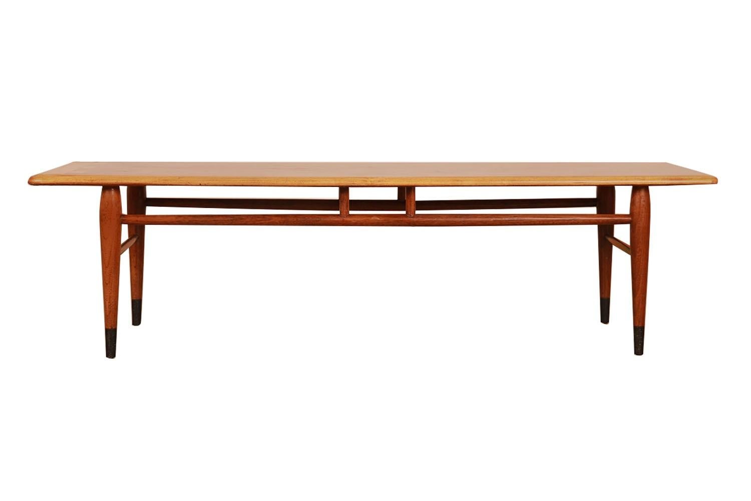 An American walnut and oak coffee table by Andre Bus for Lane Furniture in Altavista, VA. This Mid-Century Modern coffee table in walnut veneered and solid oak features beautiful contrasting dovetail detail on the top that identifies it as part of