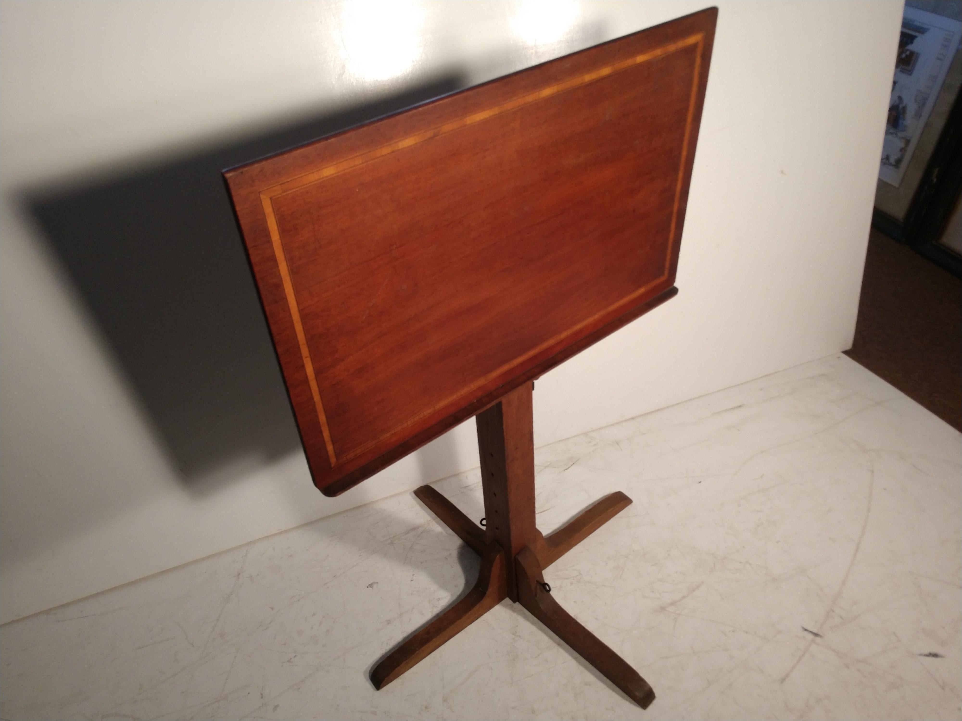 A decorative drafting table with dimensions of: 28 x 17.75 top. Min. hgt. of 29 with a max of 44, to the bottom of the tabletop. Made out of oak and walnut with a nice banding along the edge. Two legs, feet, will fold in for transportation. Great