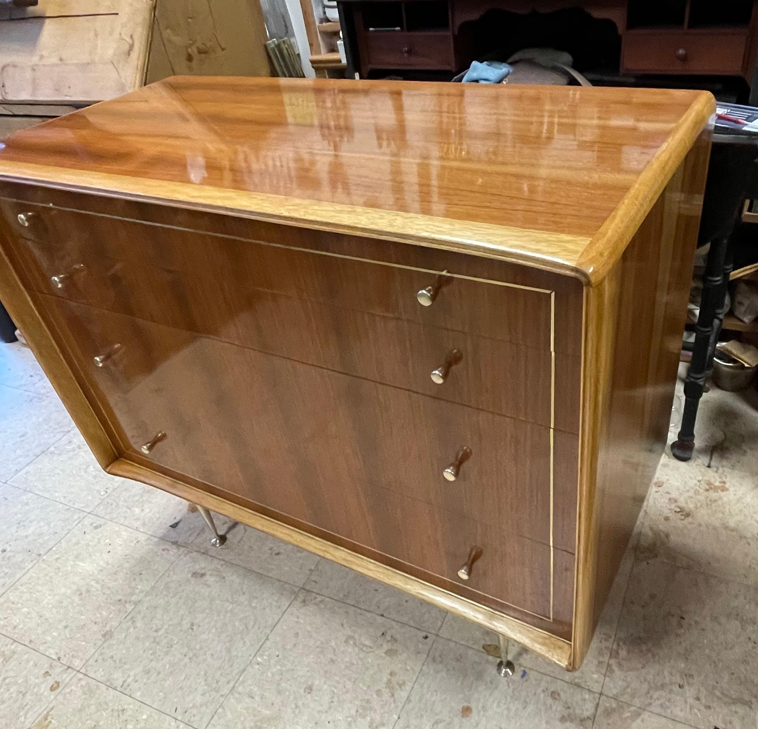 Beautiful Mid Century dresser by Erno Fabry, made in West Germany. Teak with Butternut framing, solid brass tapered legs, brass pulls and brass inlay. Professionally restored and French hand-polished by Master-craftsman Mark Mendelson, NY.

Erno