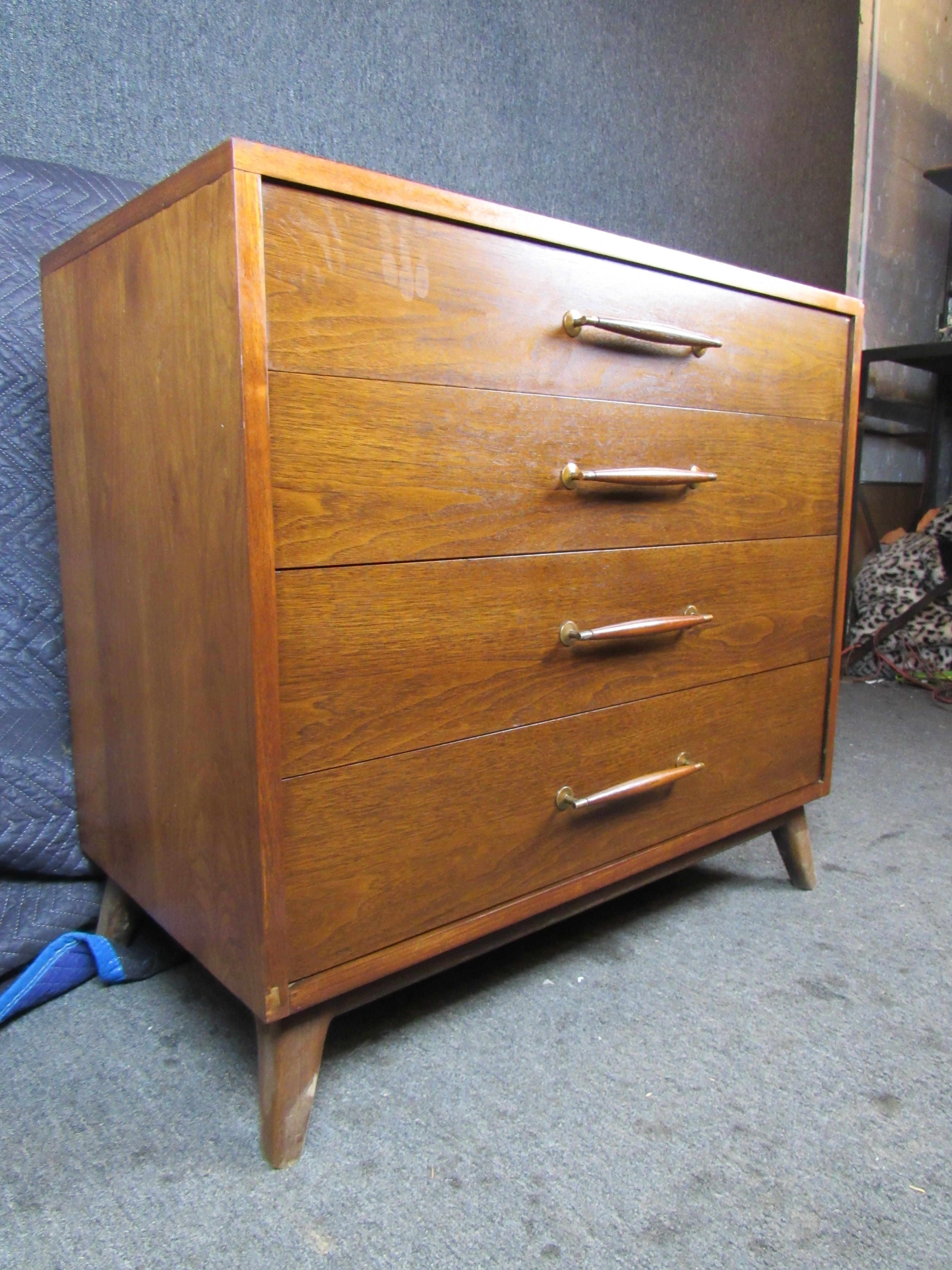 Mid-Century Modern walnut dresser by Heritage Henredon. This dresser has an exceptional design from the perpendicular inlay on the top to the brass and cherry wood stain on the handles. Its compact size makes it versatile, sure to fit amongst any