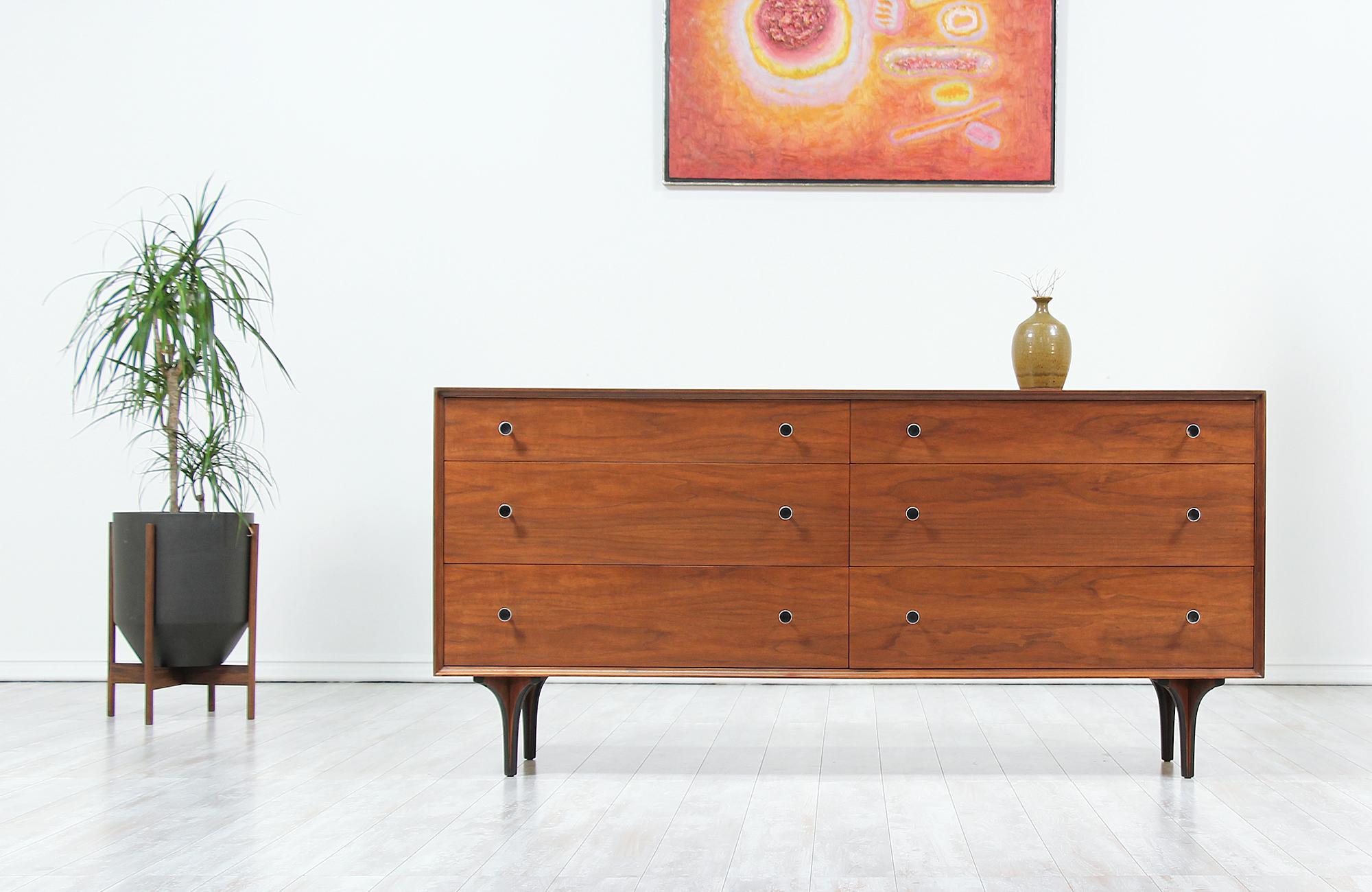 Stylish dresser designed by Robert Baron for Glenn of California, circa 1950s. This spacious dresser features a sturdy walnut wood frame with sculptural legs indicative of Glenn of California. Six drawers, each with a pair of solid steel pulls with