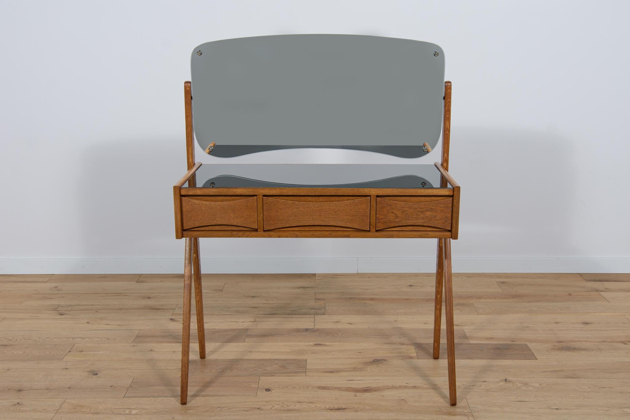 A small teak dressing table designed by Arne Vodder for Ølholm Møbelfabrik. The dressing table has three drawers. There is an adjustable mirror in the frame above the dressing table. The furniture has been completely renovated, it has been cleaned