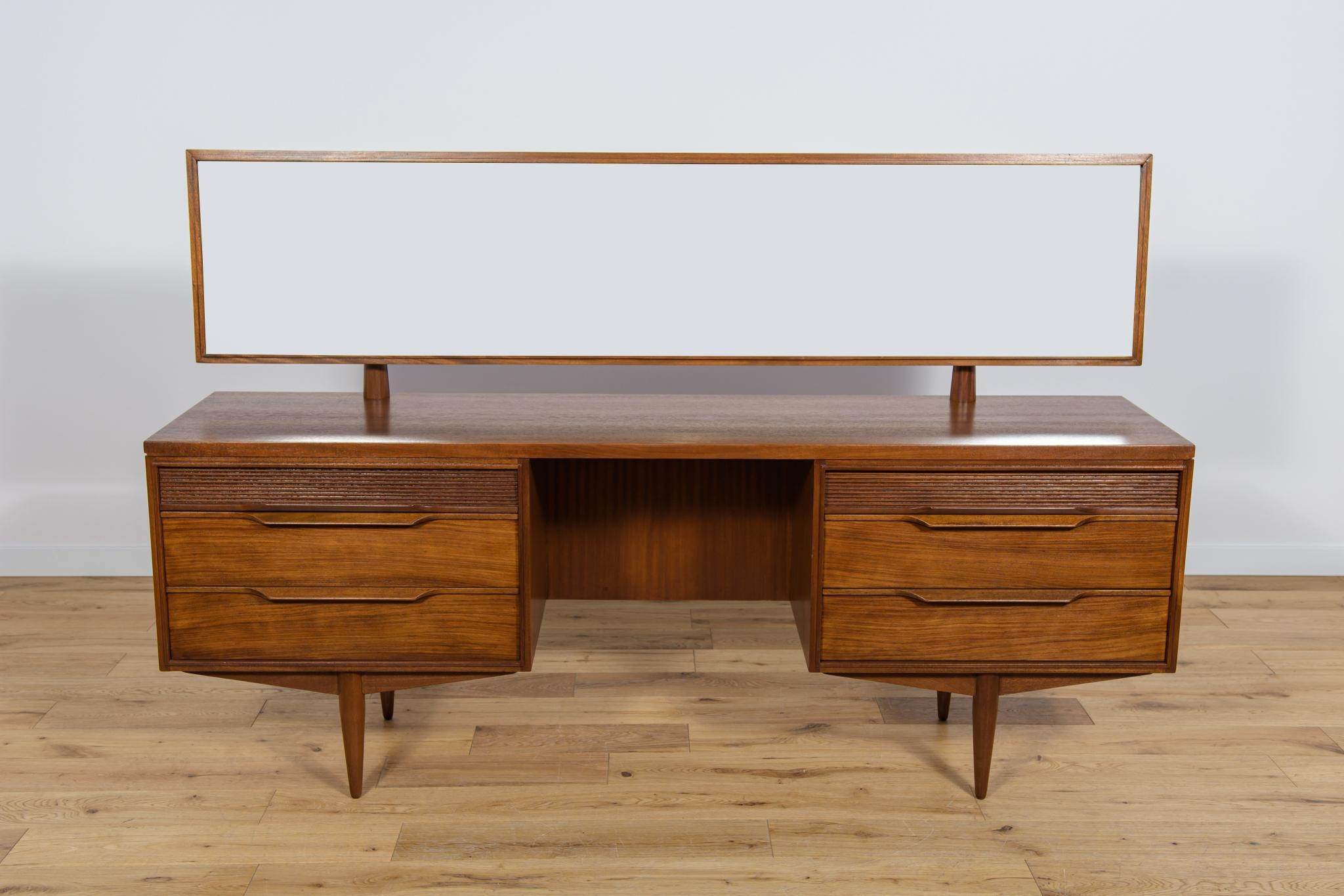 A dressing table manufactured in the British White and Newton factory in the 1960s in Portsmouth. A piece of furniture made of teak. On both sides of the dressing table there are cabinets with three drawers (the upper drawers are grooved) with