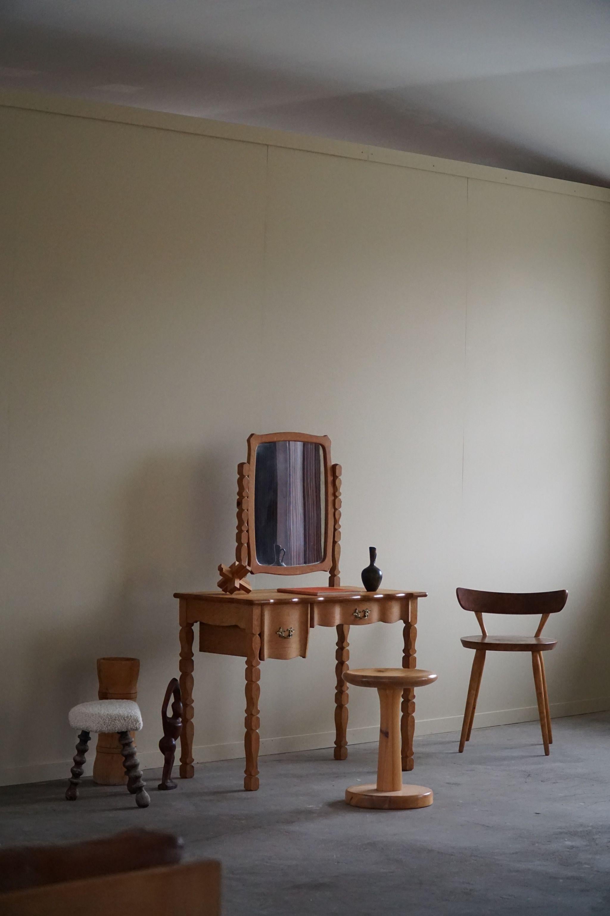 Beautiful sculptural dressing table in solid oak with brass handles, made by a Danish cabinetmaker, ca 1950s. Two drawers and a adjustable mirror. This brutalist piece is in a great vintage condition.

A fine object that fits in many interior