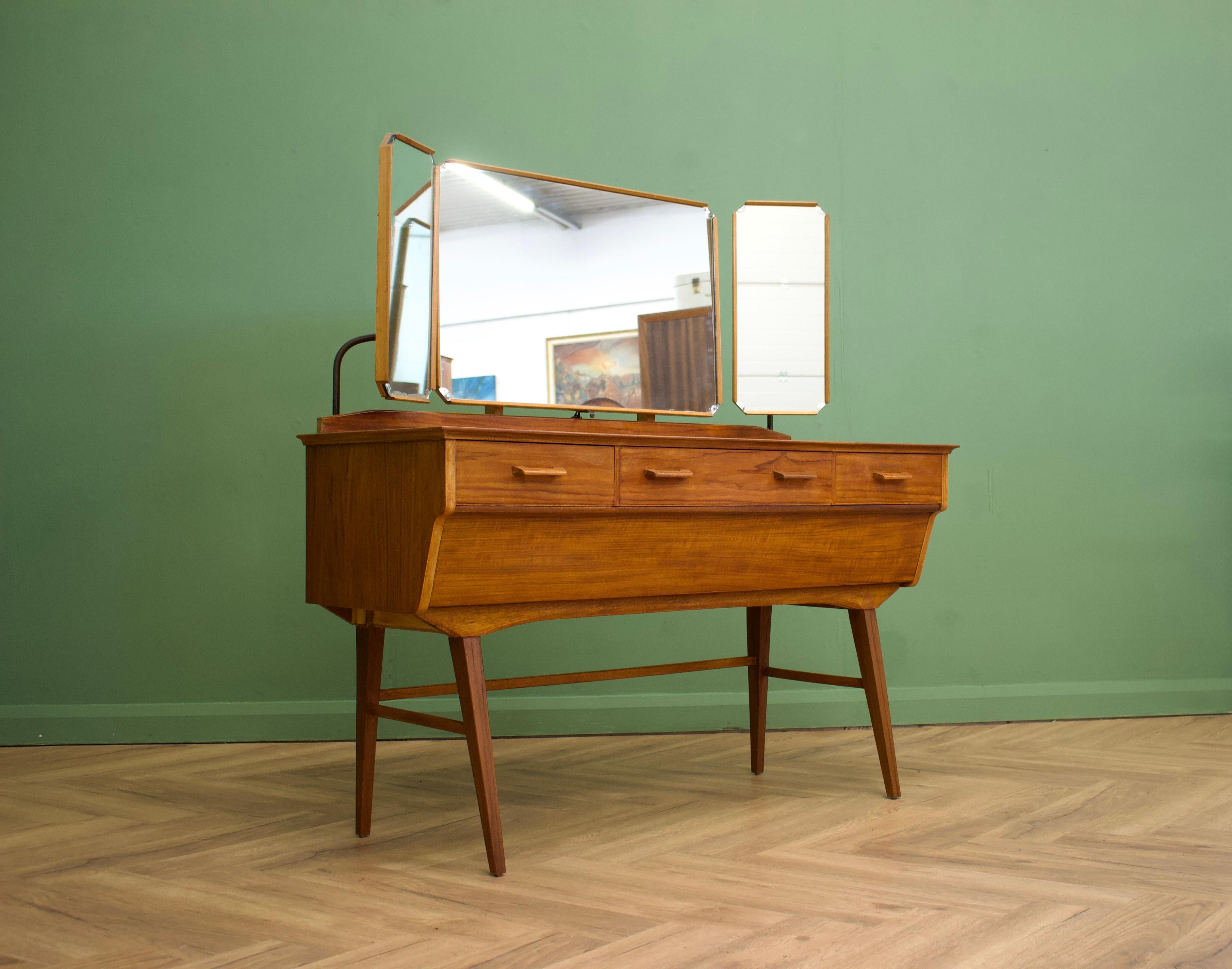 - Mid-century dressing table by Alfred Cox.
- Manufactured in the UK.

- Made from walnut & walnut Veneer.

- Featuring 5 drawers and a triptych mirror.