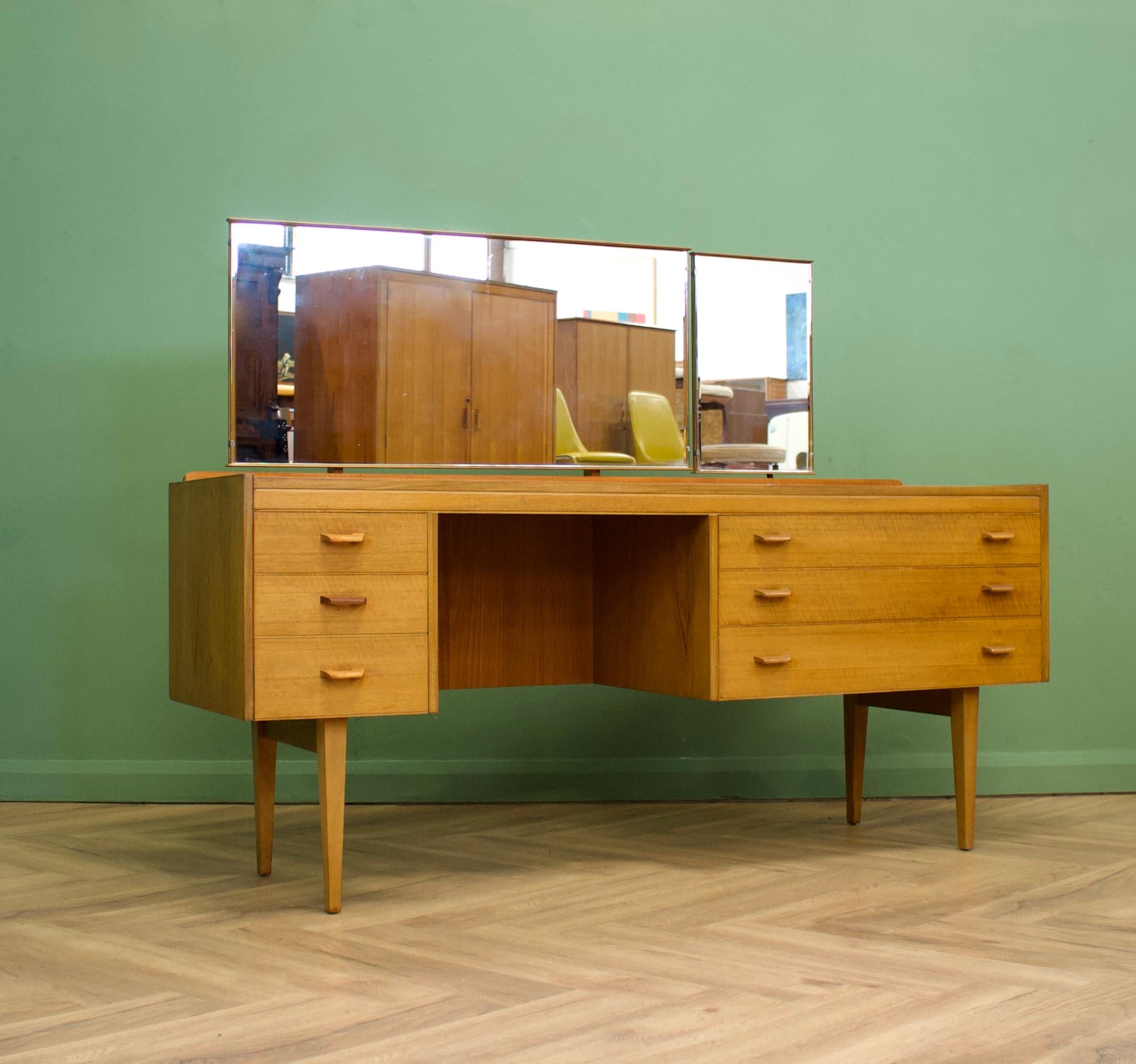 A beautiful quality walnut and teak dressing table by Alfred Cox - these pieces were usually retailed through Heals department store during the 1950s and 1960s
Featuring six drawers, with solid wood handles
The stylish legs are slightly tapered and
