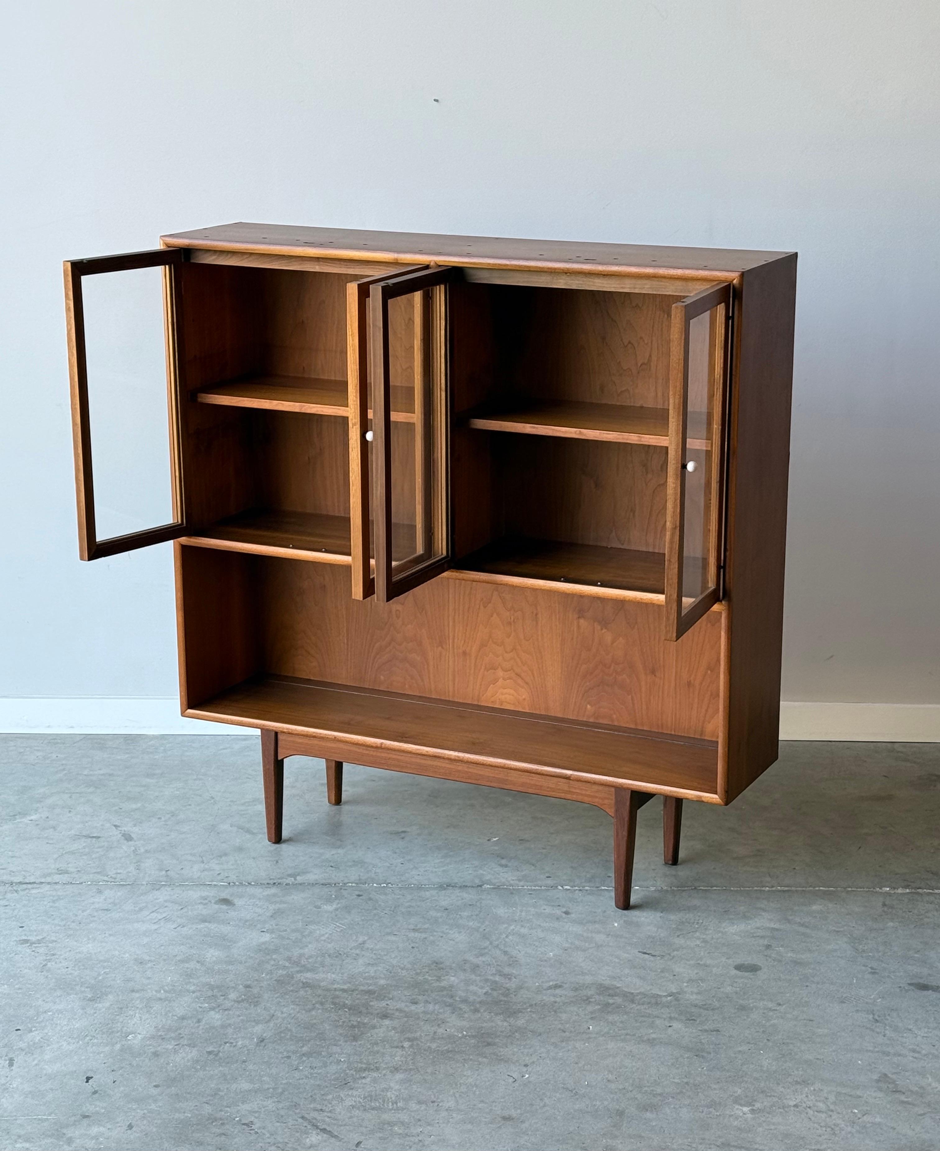 Bibliothèque du milieu du siècle par Drexel Furniture. Cette pièce en noyer, conçue à l'origine par Kipp Stewart et Stewart MacDougall, a été transformée en bibliothèque. Fabriqué en bois de noyer chaud. La moitié supérieure comporte quatre portes