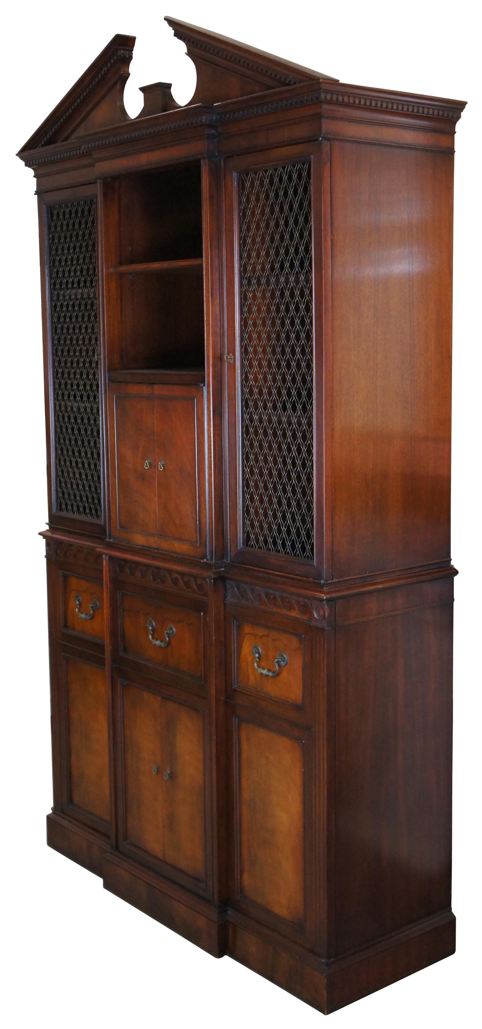 1940s Imperial Windsor cabinet by Drexel & Magnavox. A beautiful Federal style mahogany library bookcase with breakfront form. Features lattice brass wire doors, an open pediment with dentil molding and plenty of shelving for storage of books,