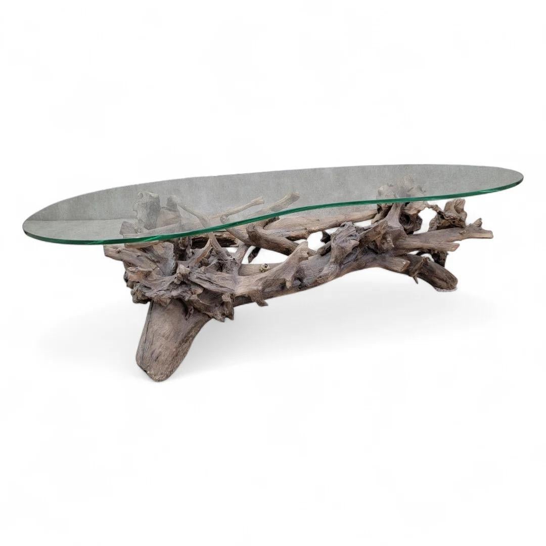 Mid Century Drift/Teak Root Live Edge Kidney Shape Glass Top Coffee Table 

The Coffee Table is a stunning blend of natural beauty and modern design. Crafted from exquisite teak root, this unique piece showcases a live edge that highlights the