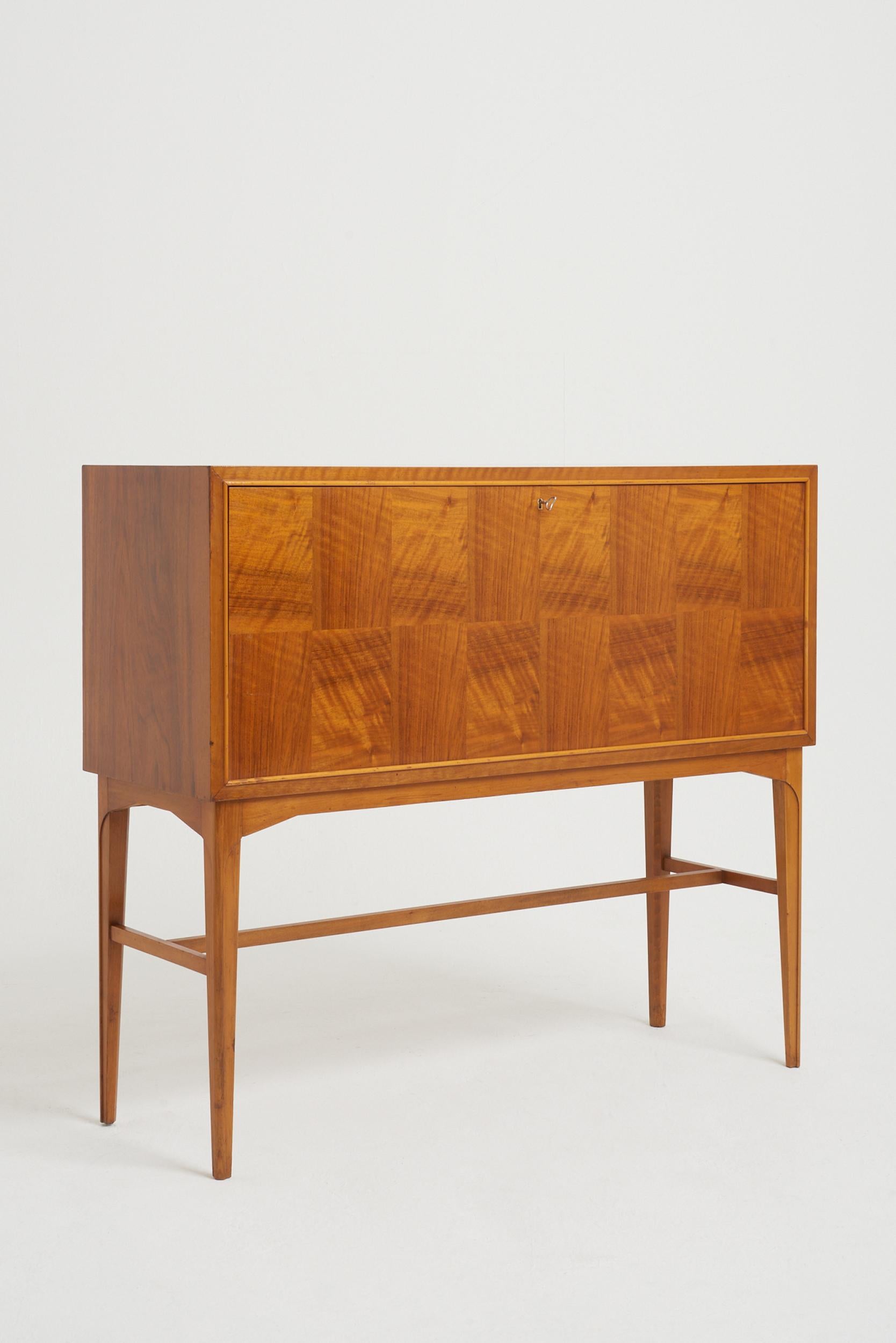 A cocktail cabinet by Carl-Axel Acking (1910-2001), mahogany, walnut and beech, the fully fitted interior with a revolving bottle compartments, drawers and glass shelves, internally lit. 
Sweden, circa 1950