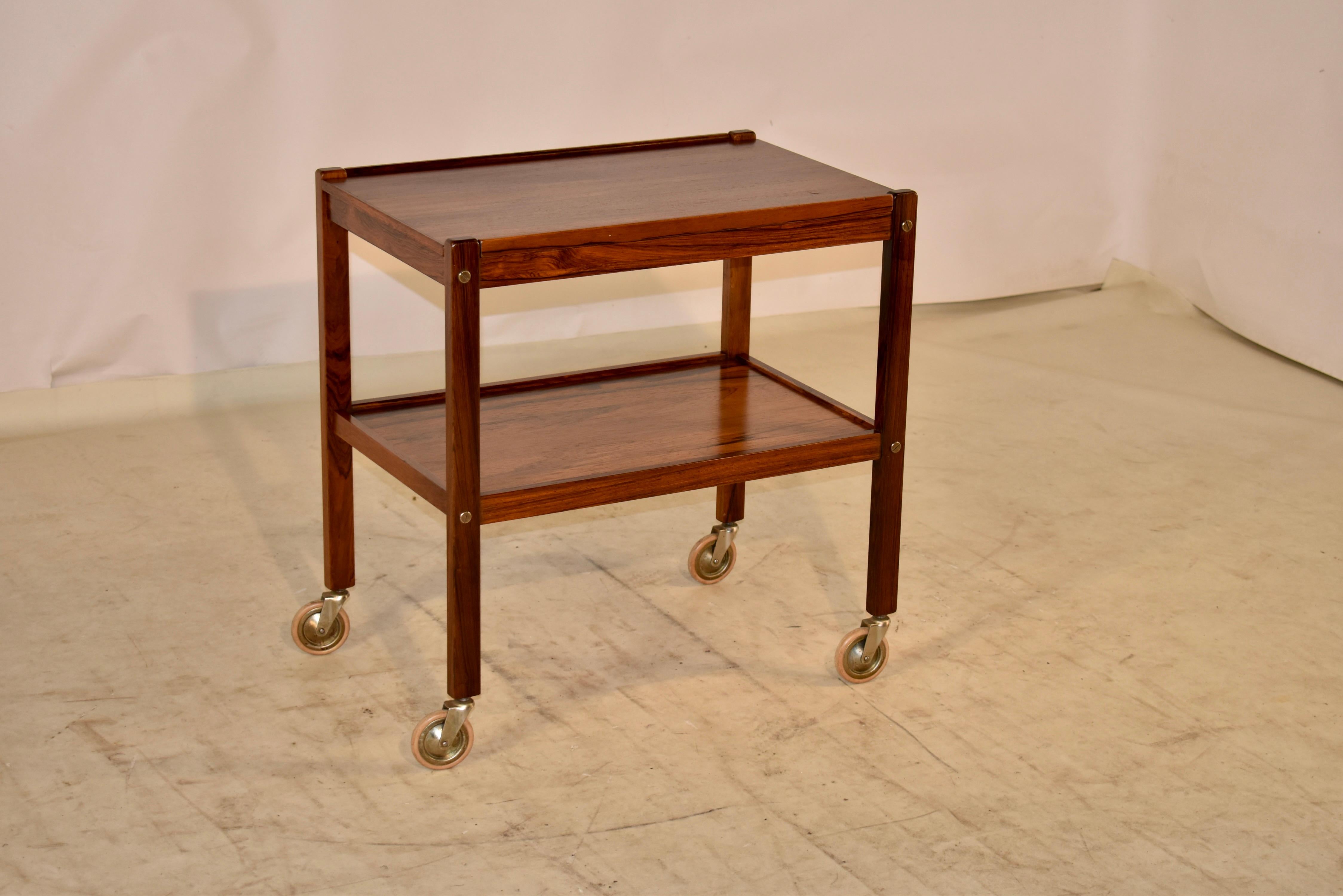 Mid-century rosewood bar or drinks cart from England. This cart is very elegant in its simplicity. The cart has simple and modern lines, to compliment any decor. The top is removable, and has gorgeous graining. It is supported on its original